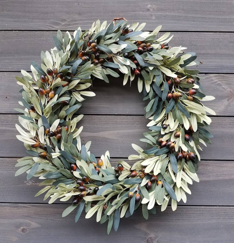 A faux olive wreath against a dark wood background.