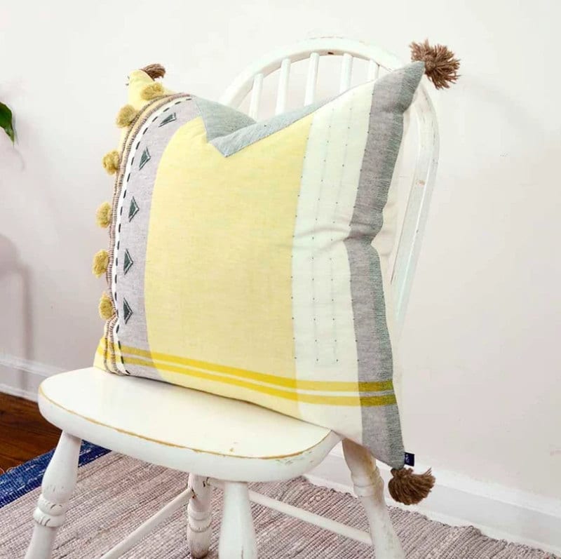 Yellow, grey and white pillow with tassels