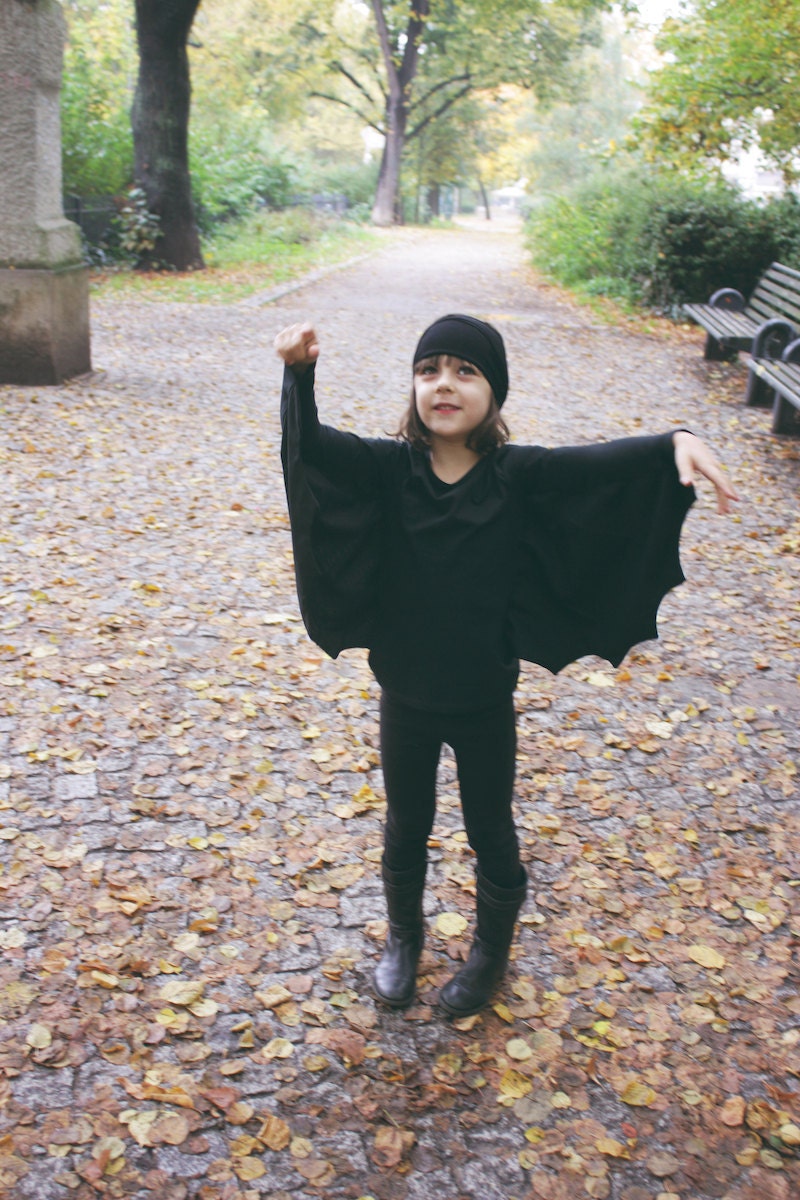 A young child wearing a handmade DIY bat costume for Halloween