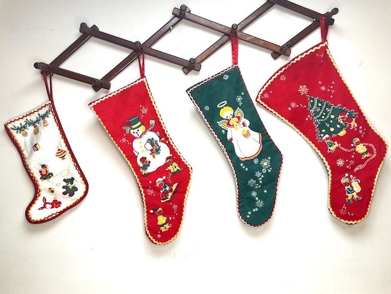 Vintage felt Christmas stockings hanging on a coat rack.