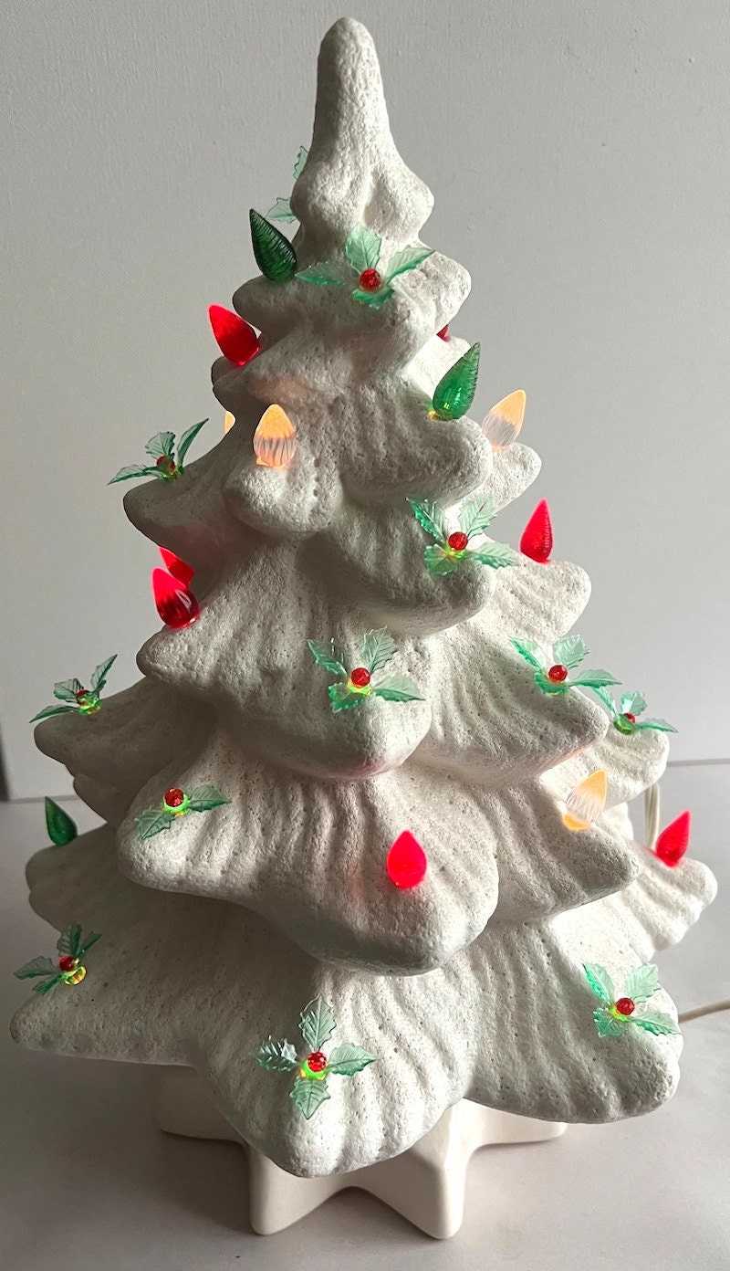 A white ceramic Christmas tree with red, green, and white lights.