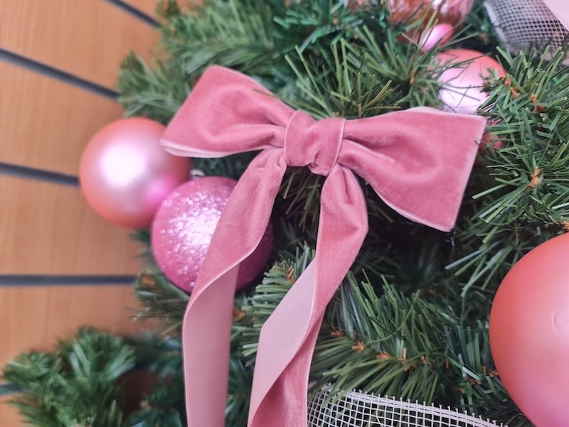A pink velvet ribbon on a Christmas tree.