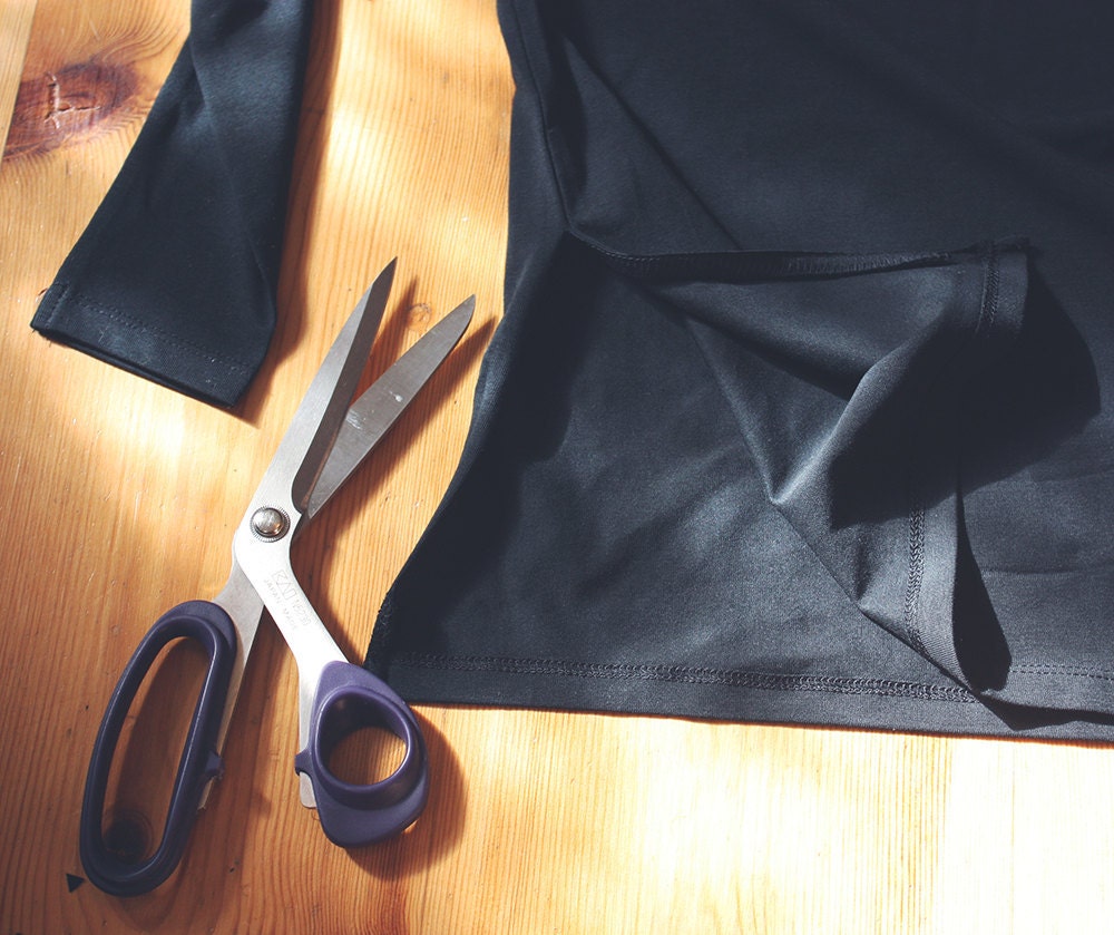 Cutting the seam of the shirt in a DIY bat costume Cutting the seam of the shirt in a DIY bat costume