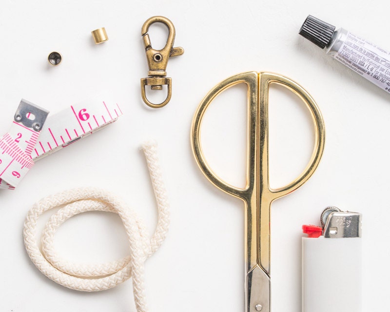 A flat lay of supplies needed to create a DIY nautical knot keychain. A flat lay of supplies needed to create a DIY nautical knot keychain.