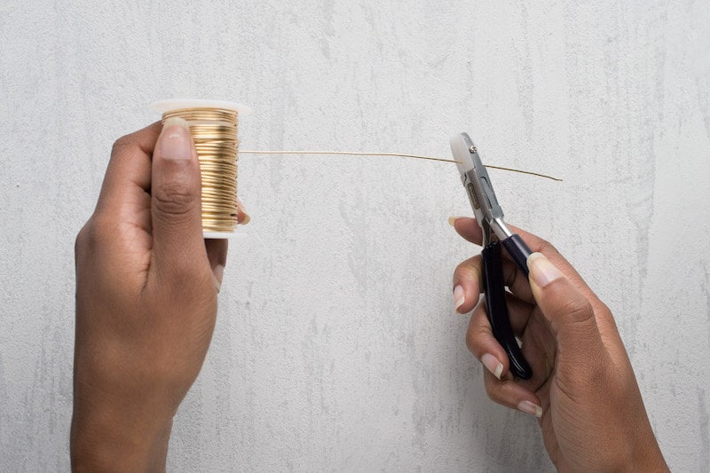 Image of hands holding the spool and straightening the wire with nylon jaw pliers. Image of hands holding the spool and straightening the wire with nylon jaw pliers.