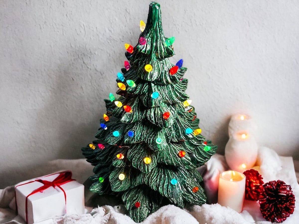 A green vintage ceramic Christmas tree with multicolored lights.