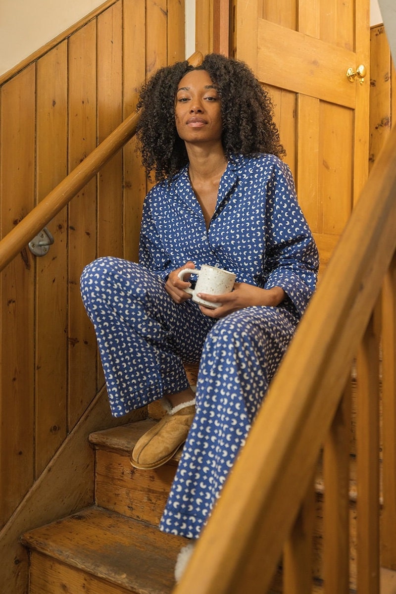 A Black woman wearing a matching cotton pajamas set.
