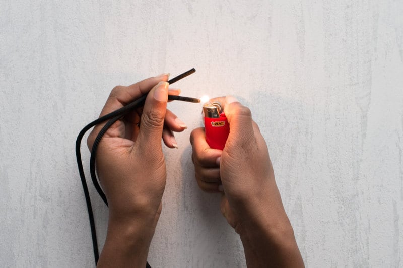 Image of hands sealing necklace ends with a lighter. Image of hands sealing necklace ends with a lighter.
