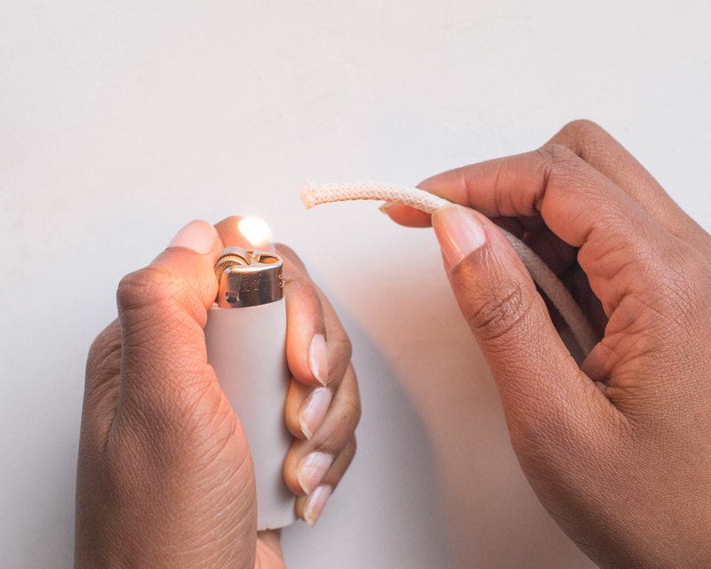 Hands sealing ends with a lighter. Hands sealing ends with a lighter.