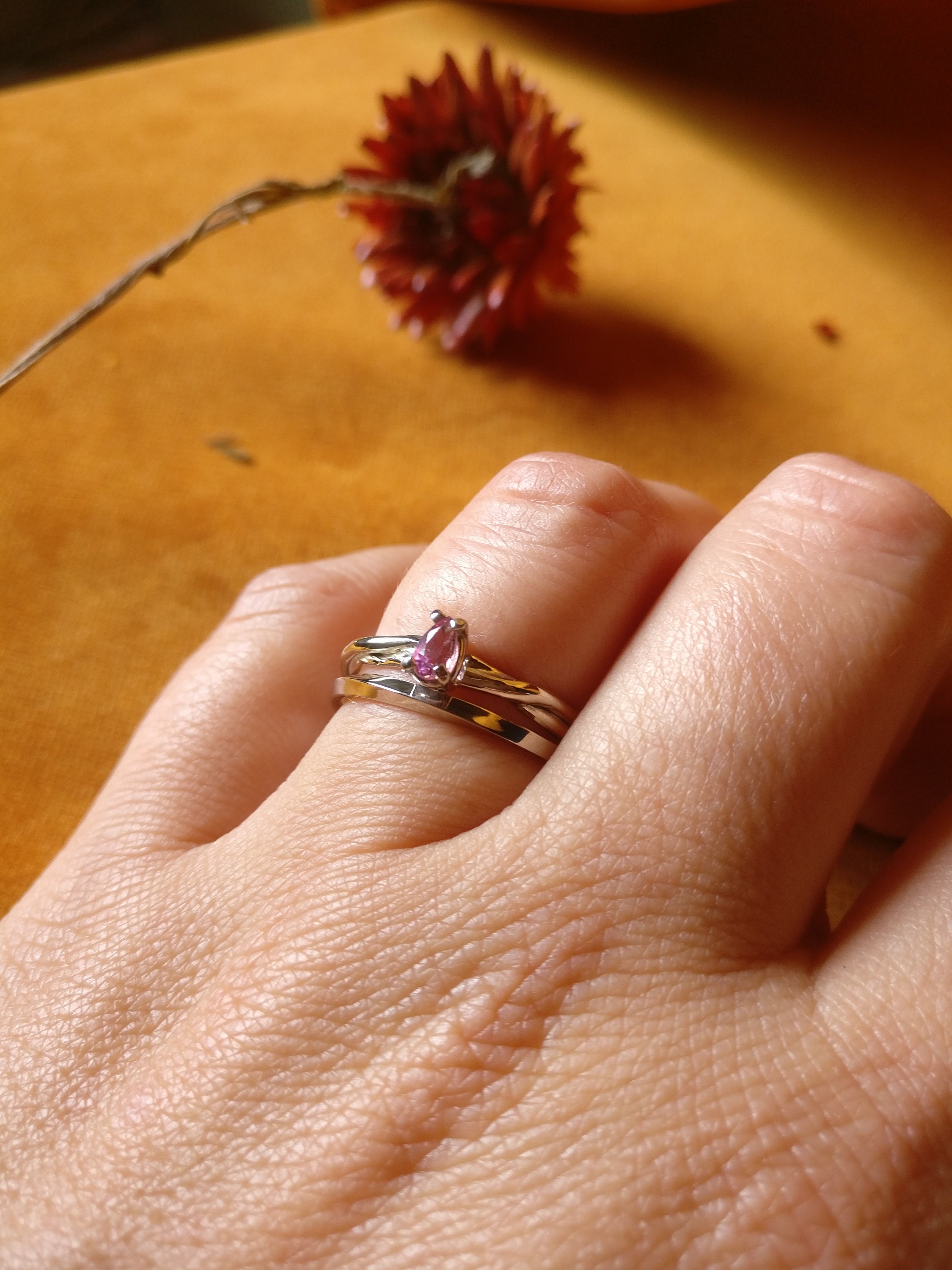 twee witgouden ringen met draaiing, afgewerkt met roze peer toermalijn
