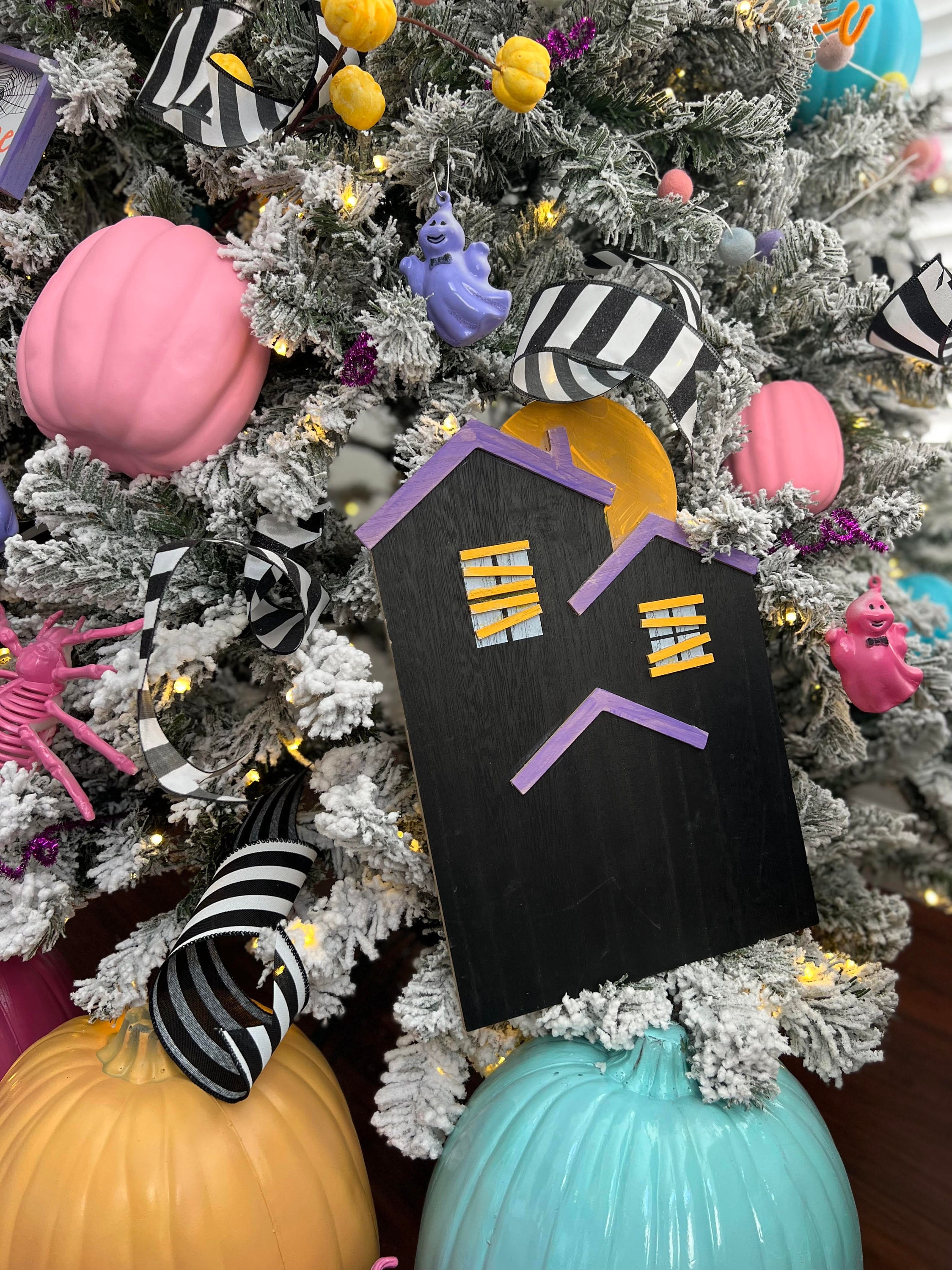 black house with pumpkins and ghosts around it