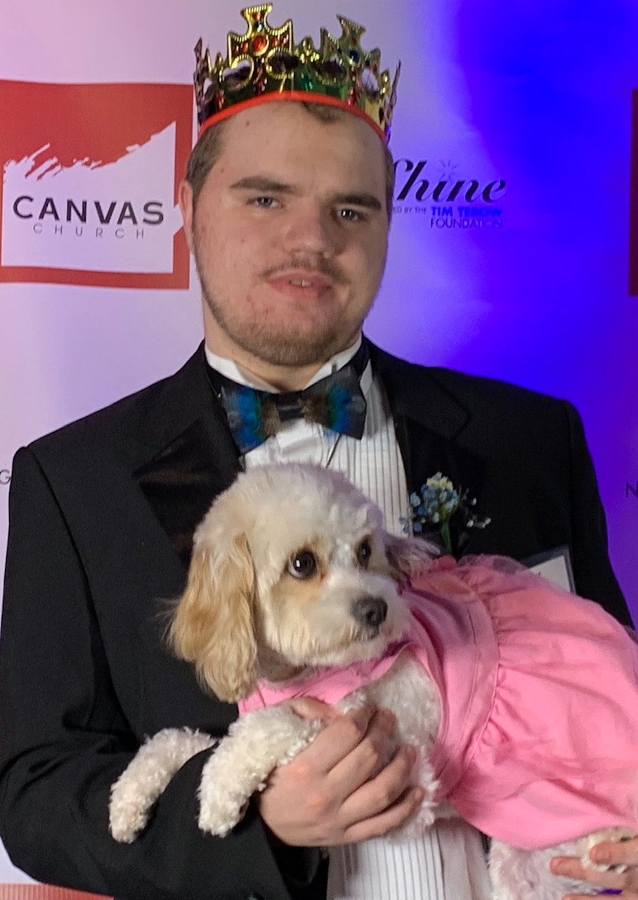 Colton with his sweet service dog Pink at Night to Shine