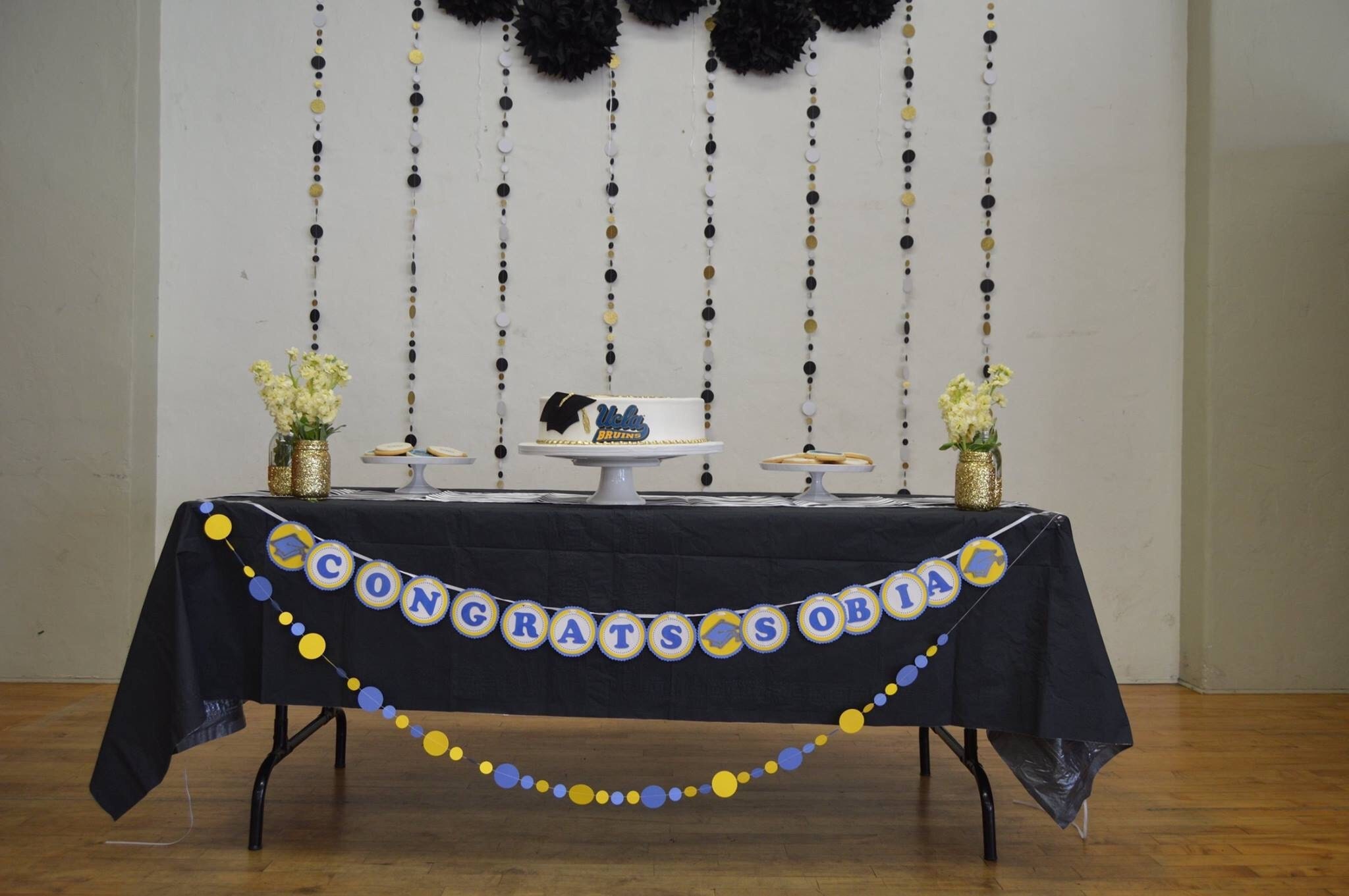Congratulations banner with UCLA decor and gold and black glitter garlands