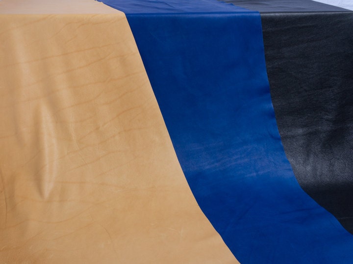 Three hides of leather including tan, blue, and blue metallic leather.
