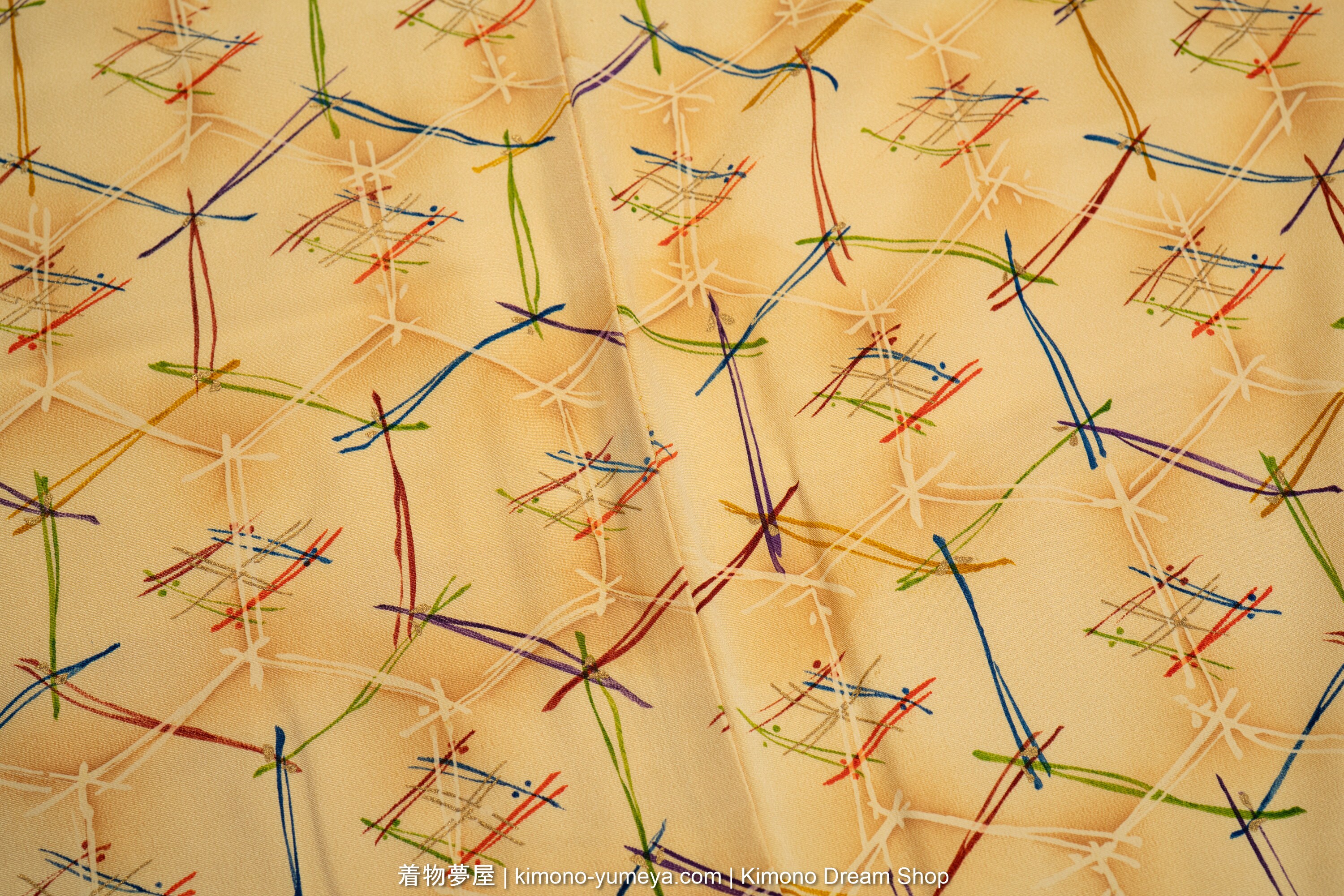 Colorful pine needles arranged in a tortoise shell pattern on a beige background.