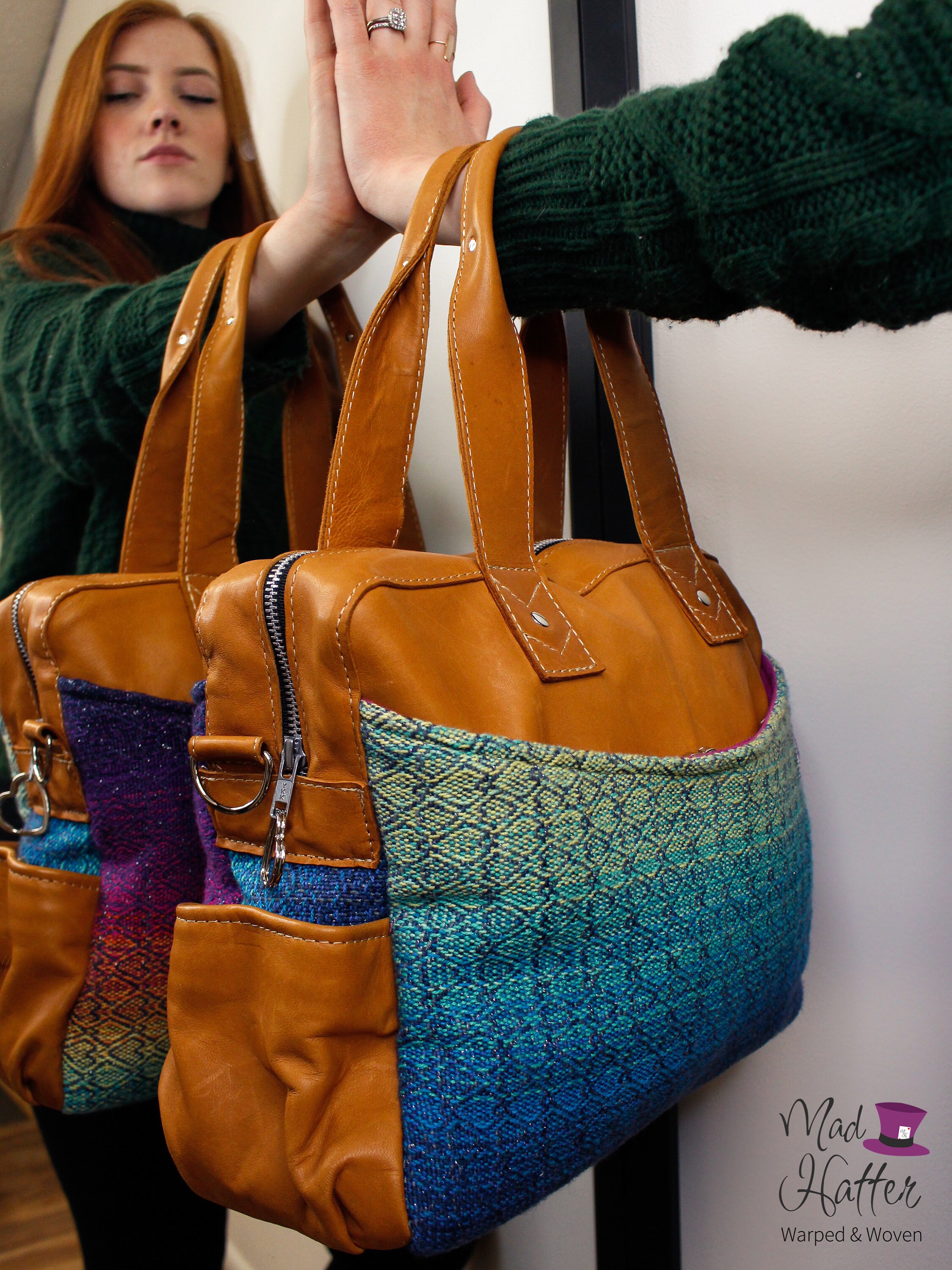 woman standing in front of a mirror with her hand pressed against the mirror and a Mad Hatter Warped & Woven Lovato Handbag with tan leather.