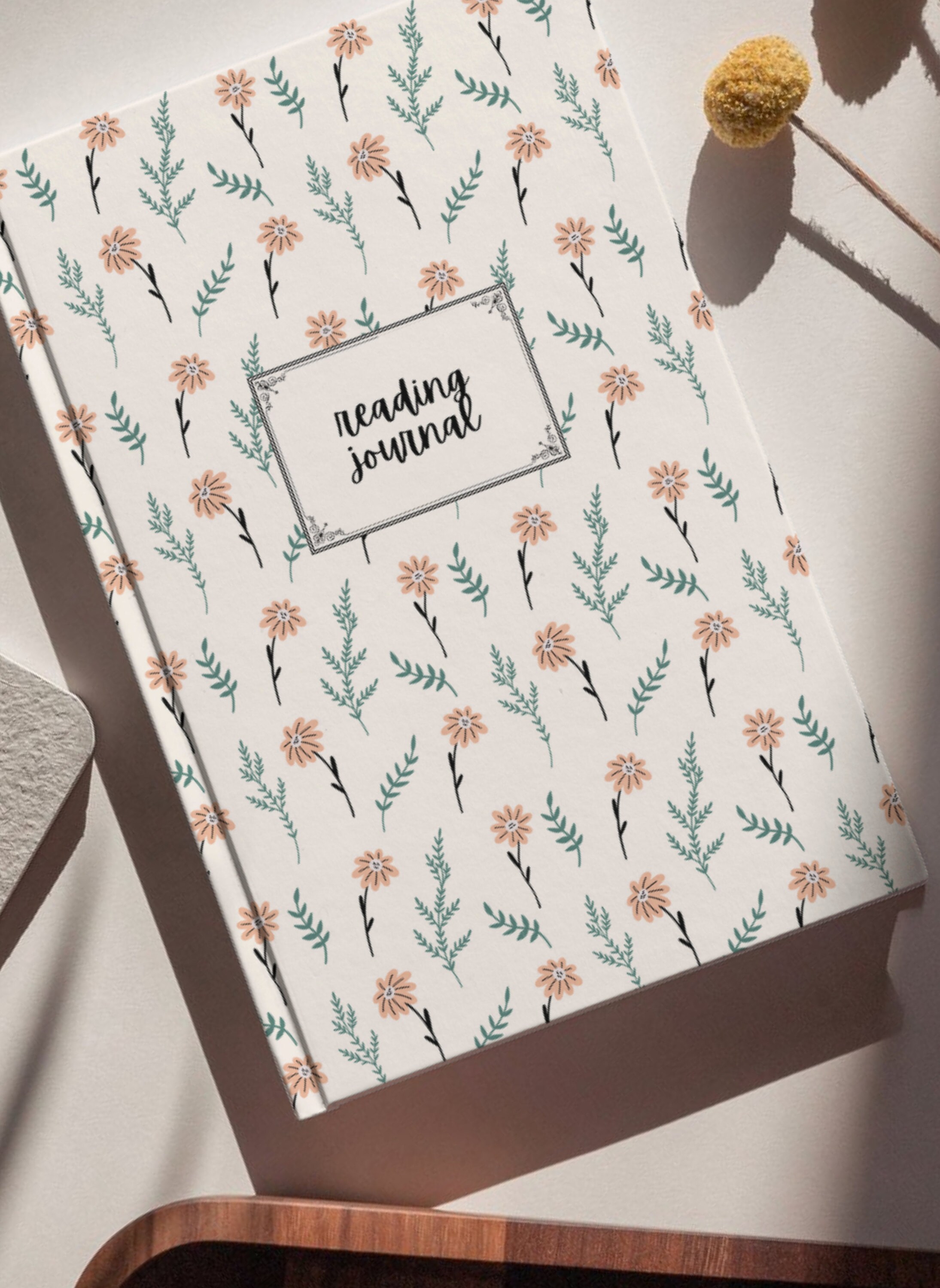 floral design on a beige/pink cover, with reading journal written in cursive lettering at the center