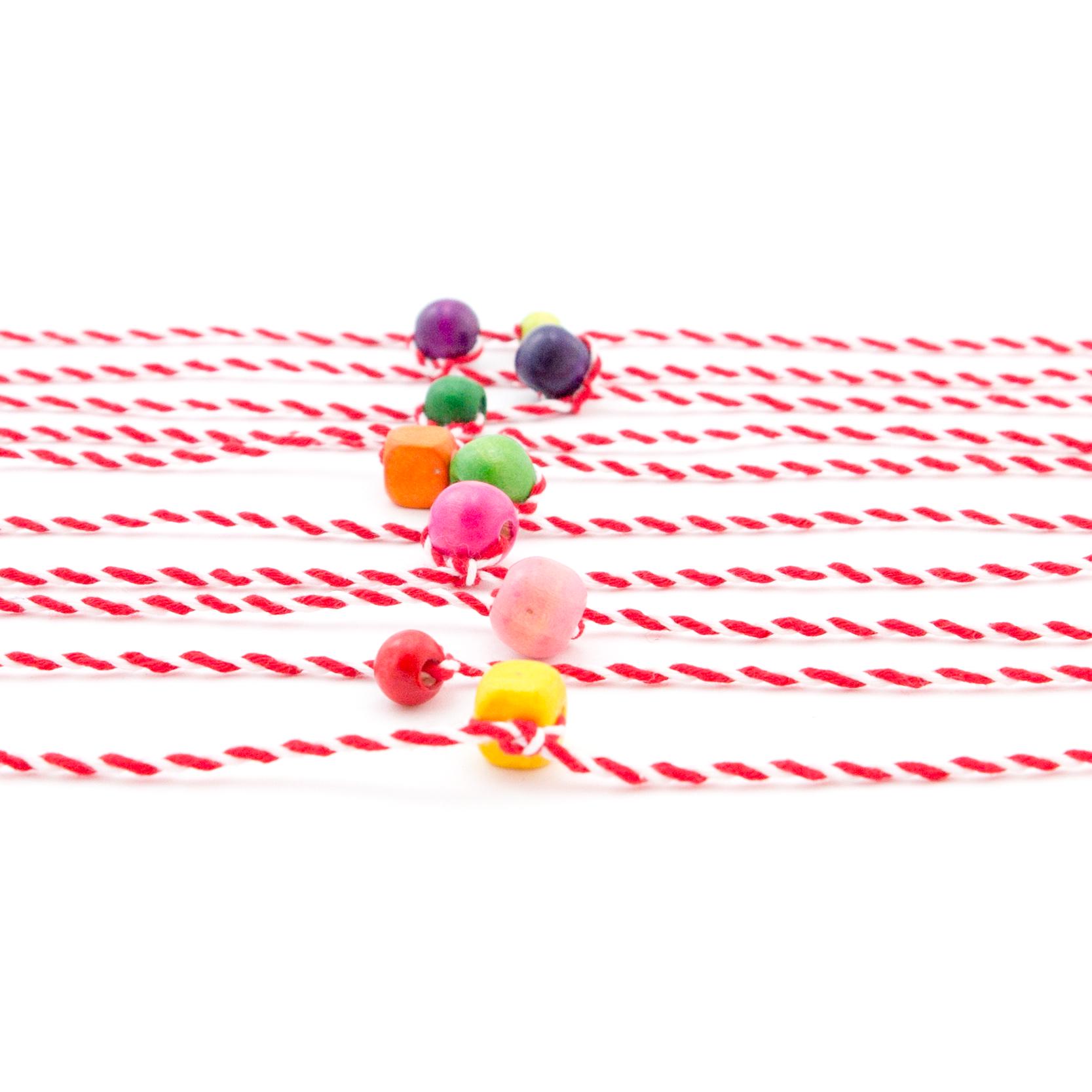 Traditional Martenica bracelet featuring red and white string and natural wooden bead