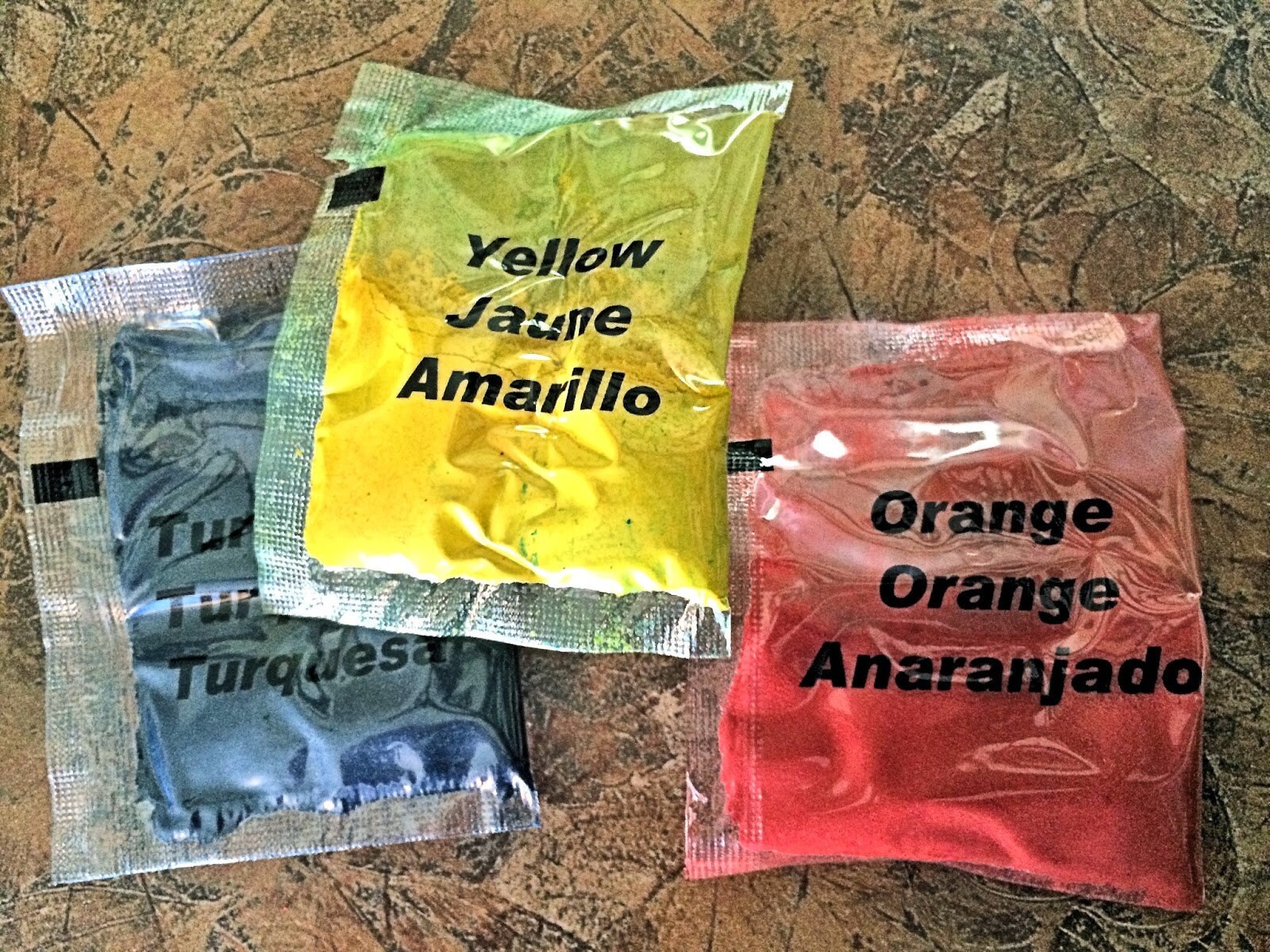 Three dye bottles — turquoise, yellow, and orange — ready to use