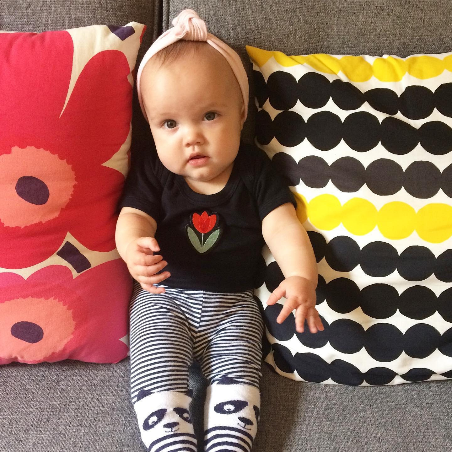 Lottie Piia wearing babygrow with Suzie London Tulip Embroidered patch