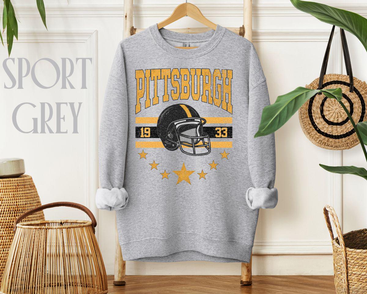 Retro Pittsburgh football graphic sweatshirt — arched ‘PITTSBURGH,’ black-and-gold stripes, classic helmet, ‘1933,’ star ring—vintage varsity style.