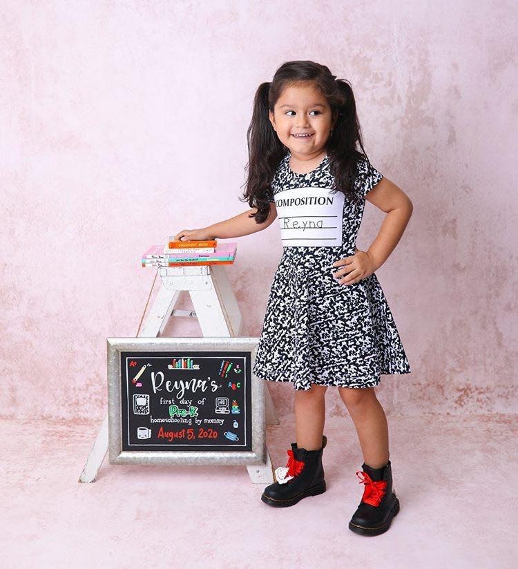 little girl with back to school board