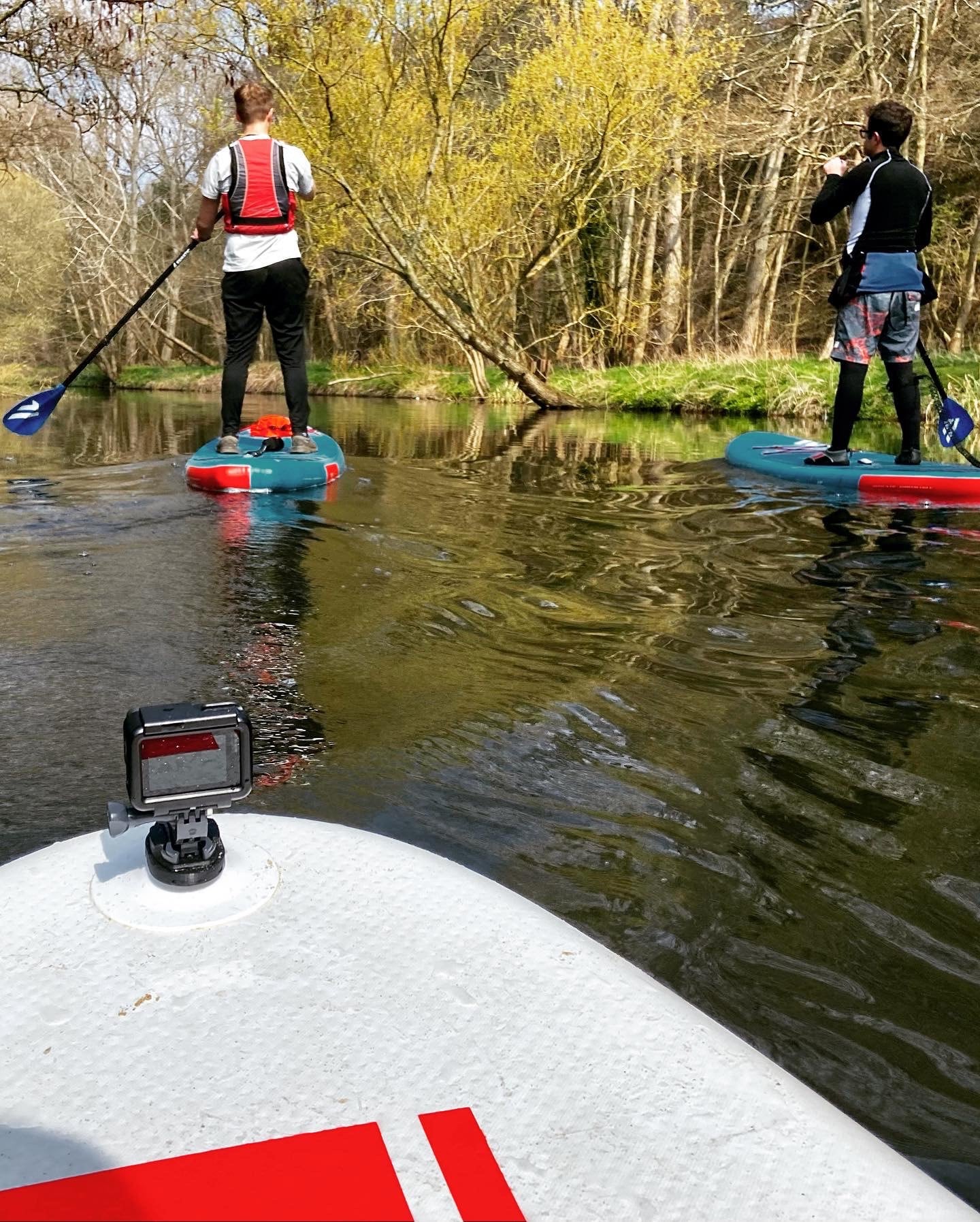 Three paddle boarders on a river