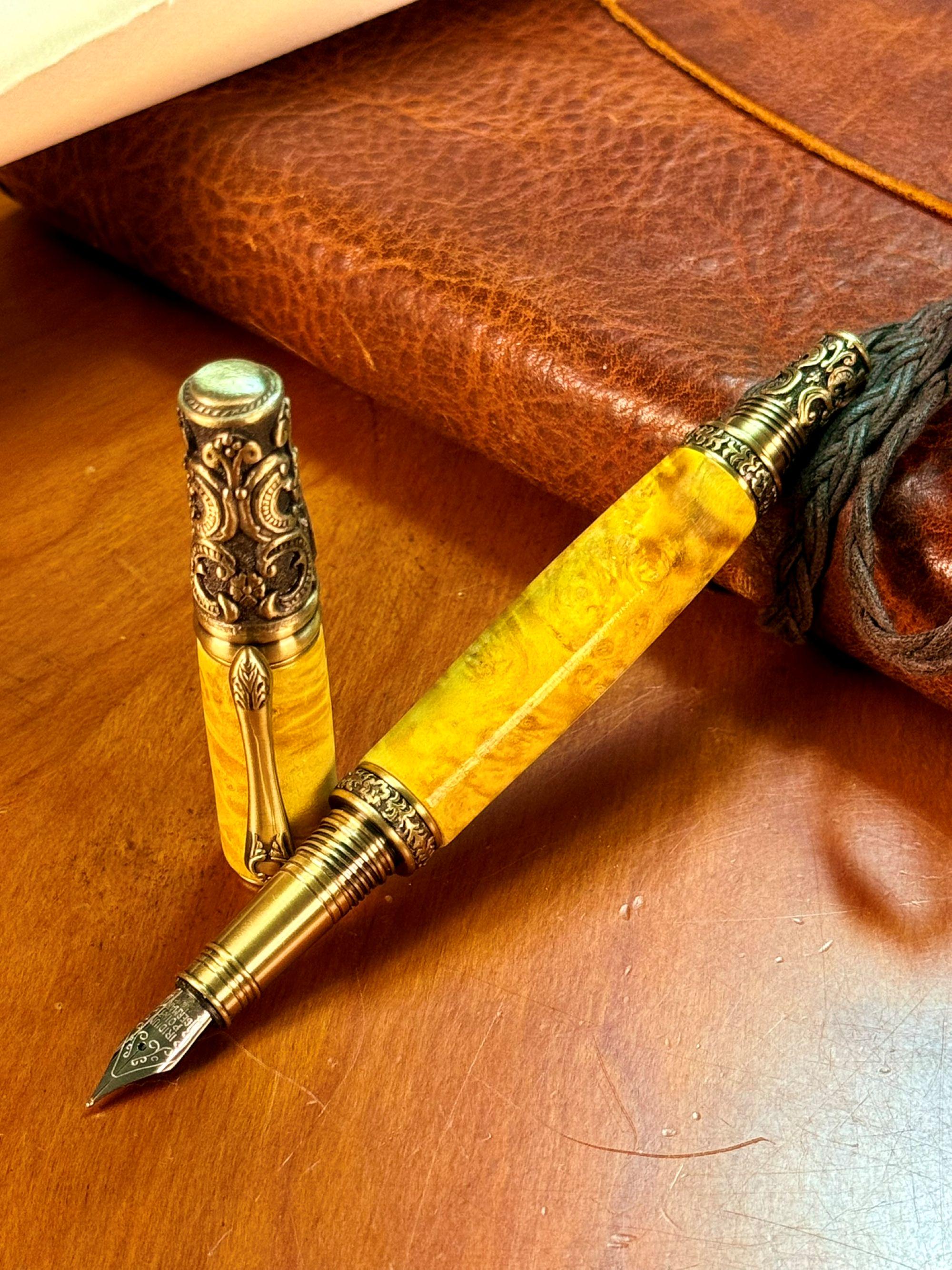 A Victorian Style Fountain pen. This pen has antique brass trim, a body made from yellow dyed buckeye burl wood. The nib is a #5 Stainless Steel medium nib tipped with iridium