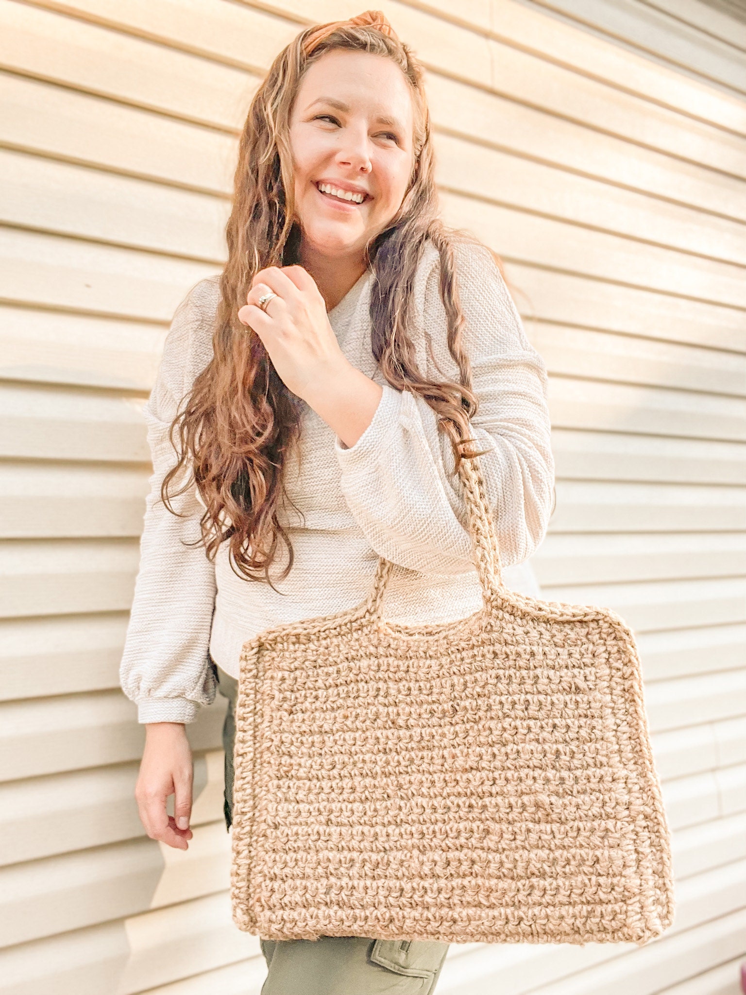 Woman carrying a crochet, jute laptop bag