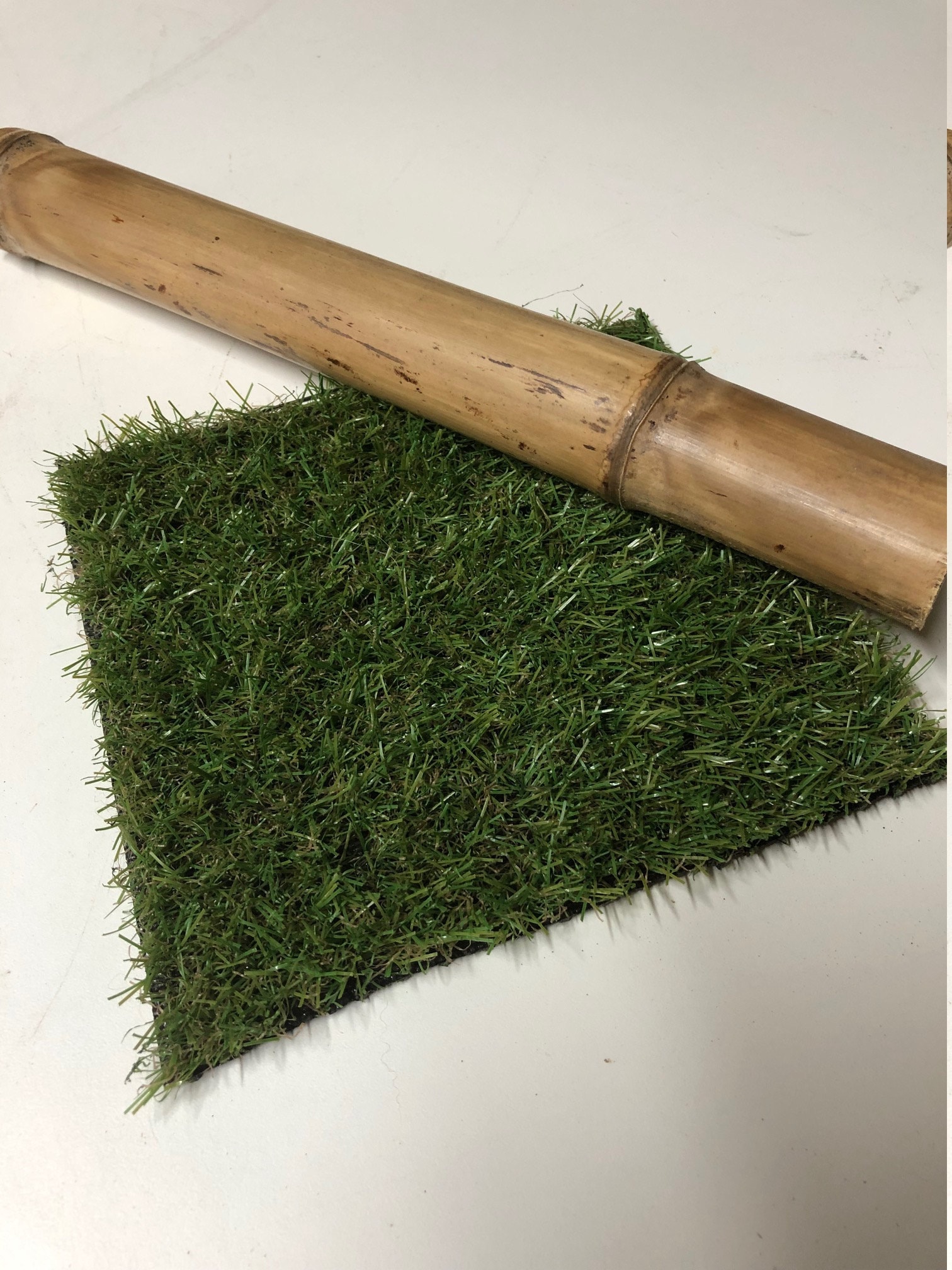 Artificial grass off-cut and a piece of bamboo