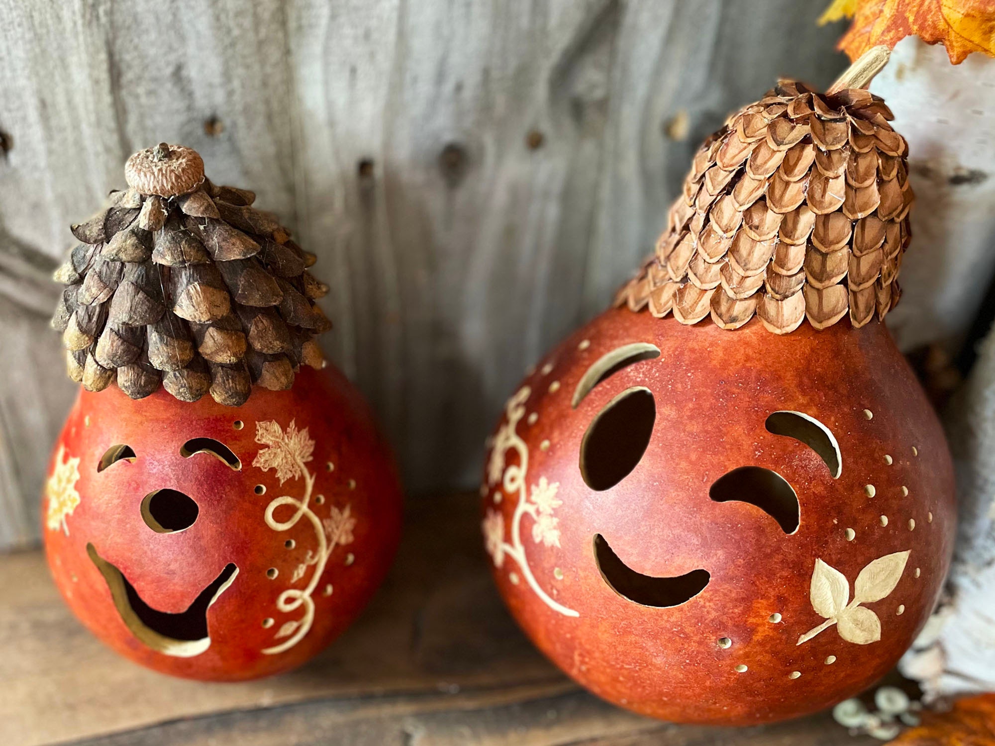 Carved gourds for fall with pine cone hats.