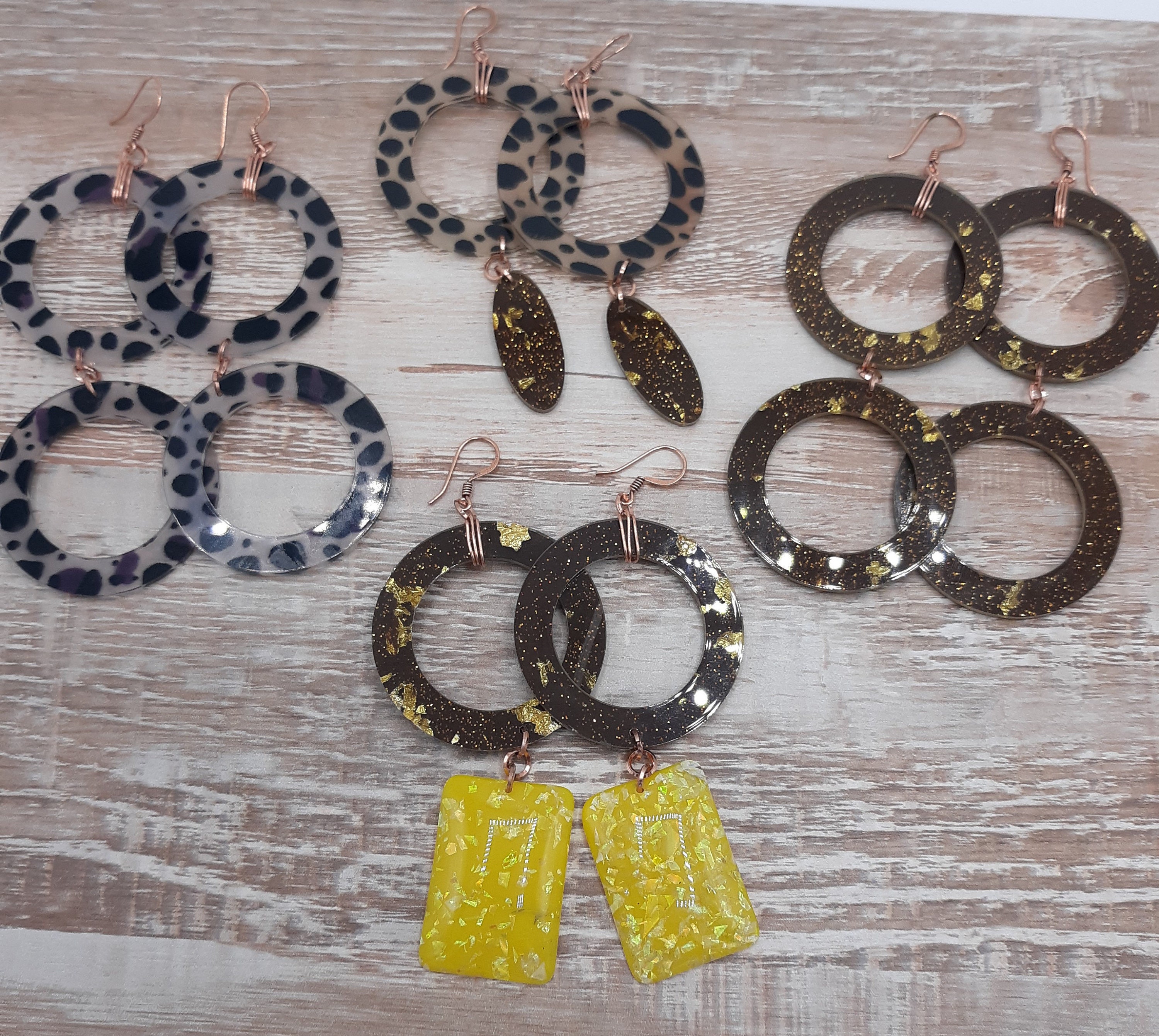 big chunky earrings in acrylic colors of gold and brown, yellow sparkle and animal print.  Big round hoops, some double hoops