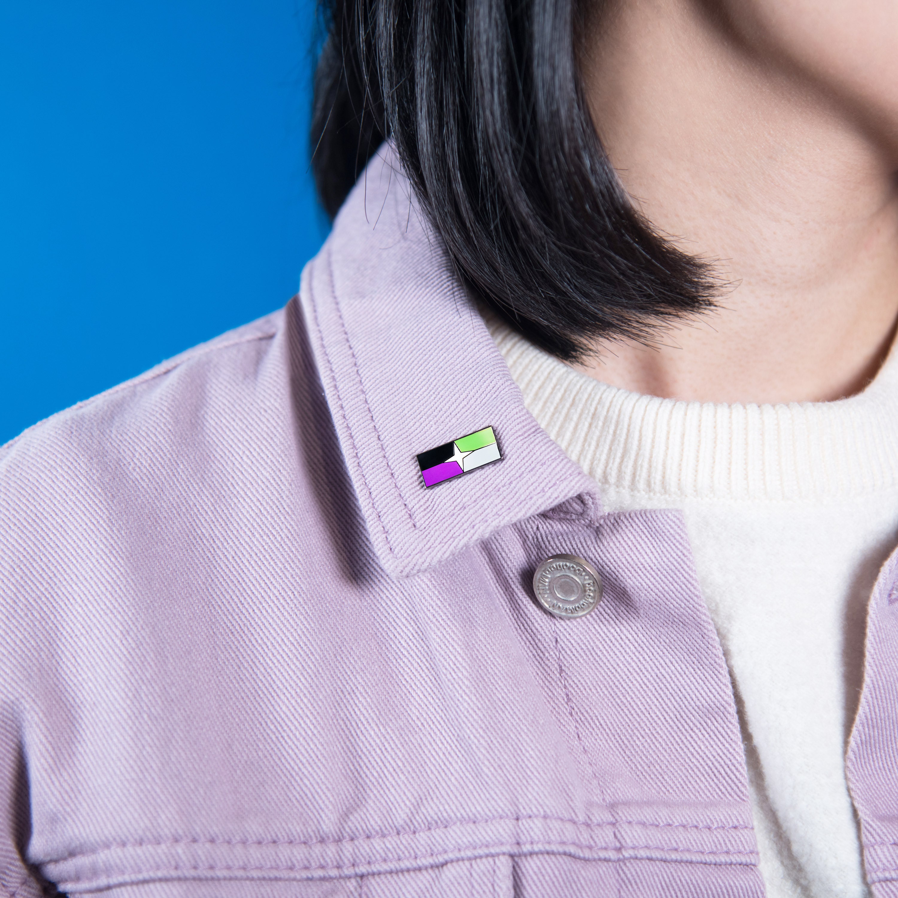 Enamel pin featuring the A-spec Pride Flag design. The pin has a minimalist and discreet style.