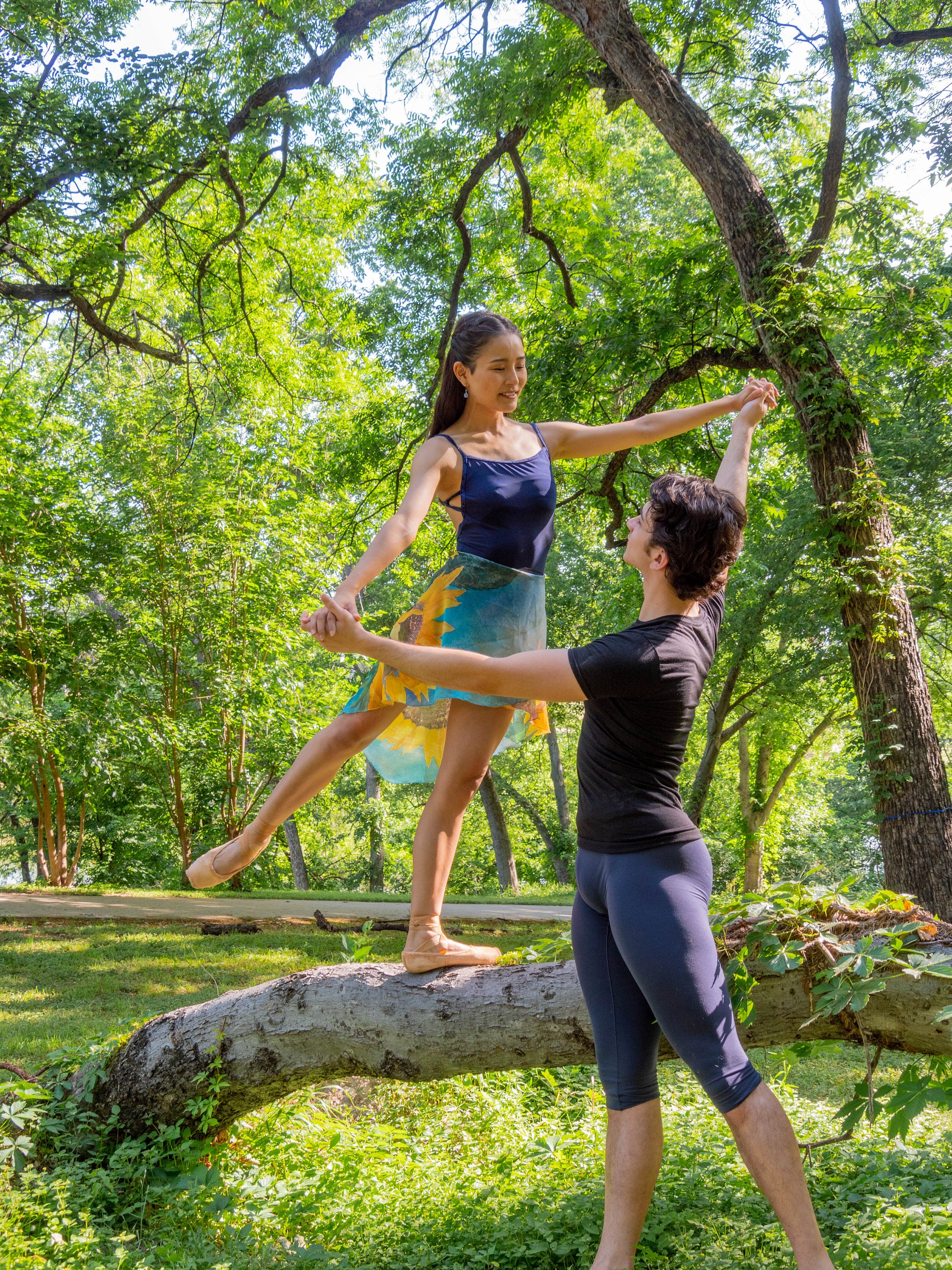 dancer in sunflower skirt on tree trunk