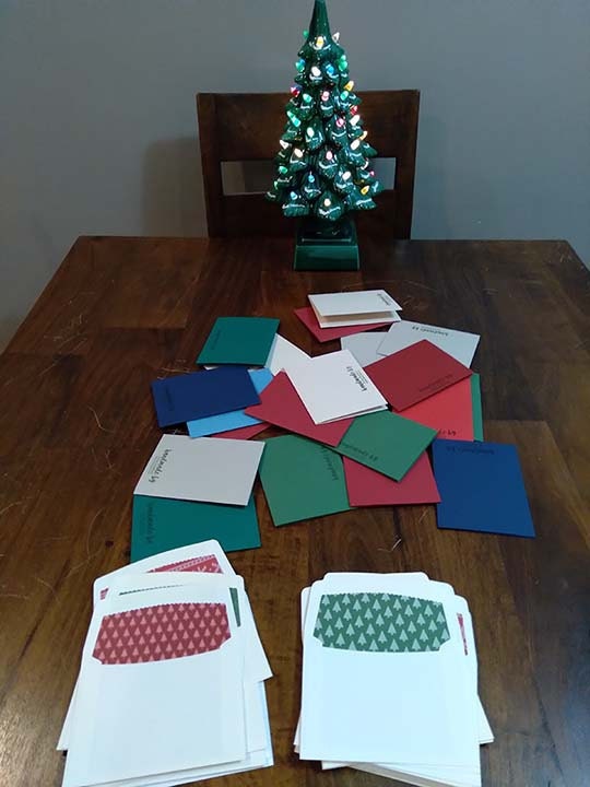 Christmas cards and envelopes spread out on a table