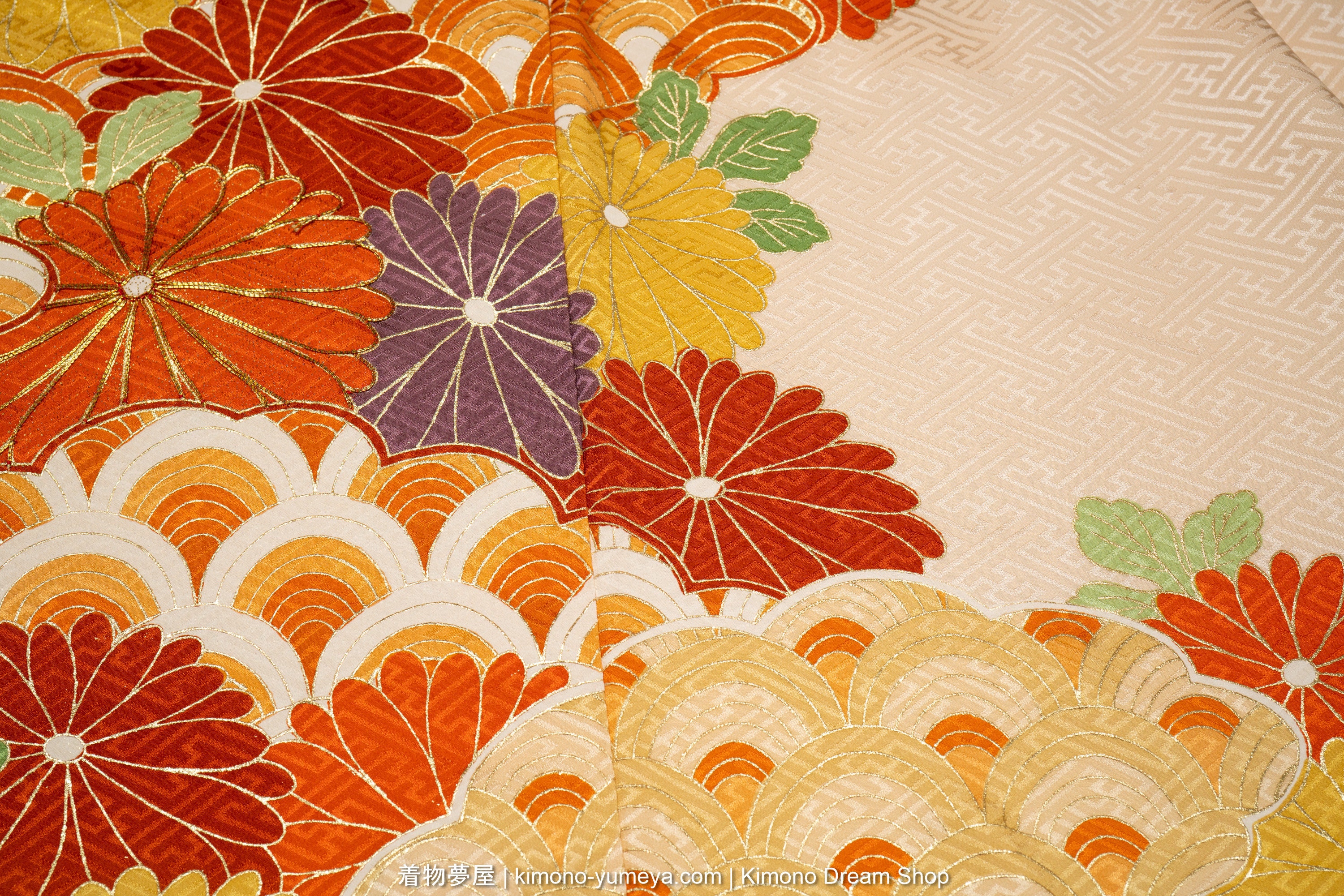 Seigaiha patterns made up of gold, white, yellow, orange, beige, and red, surrounded by chrysanthemums.