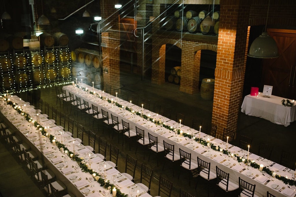 Photo of event space with two long tables and wedding stationery