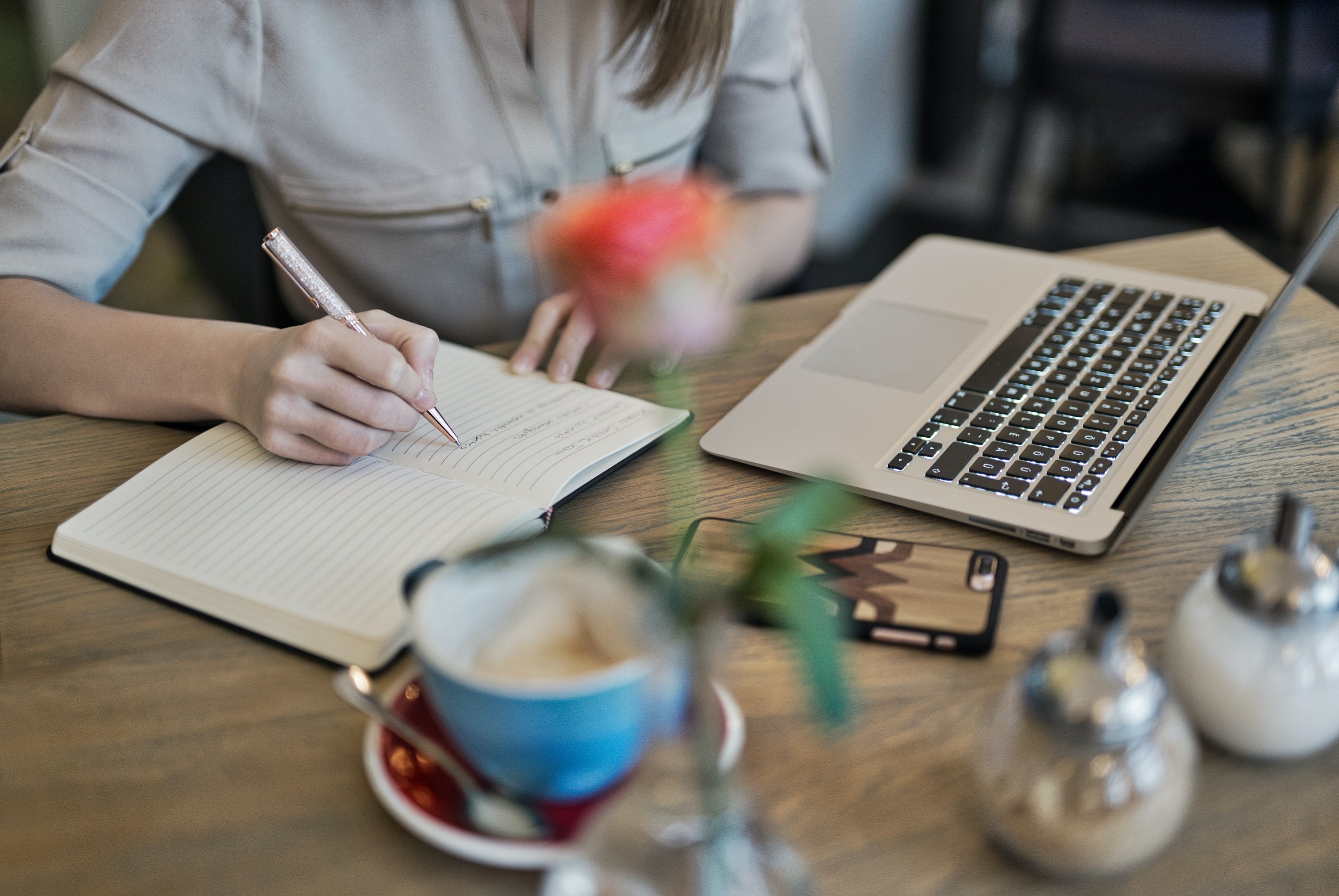 Photo by Judit Peter: https://www.pexels.com/photo/person-writing-on-a-notebook-beside-macbook-1766604/