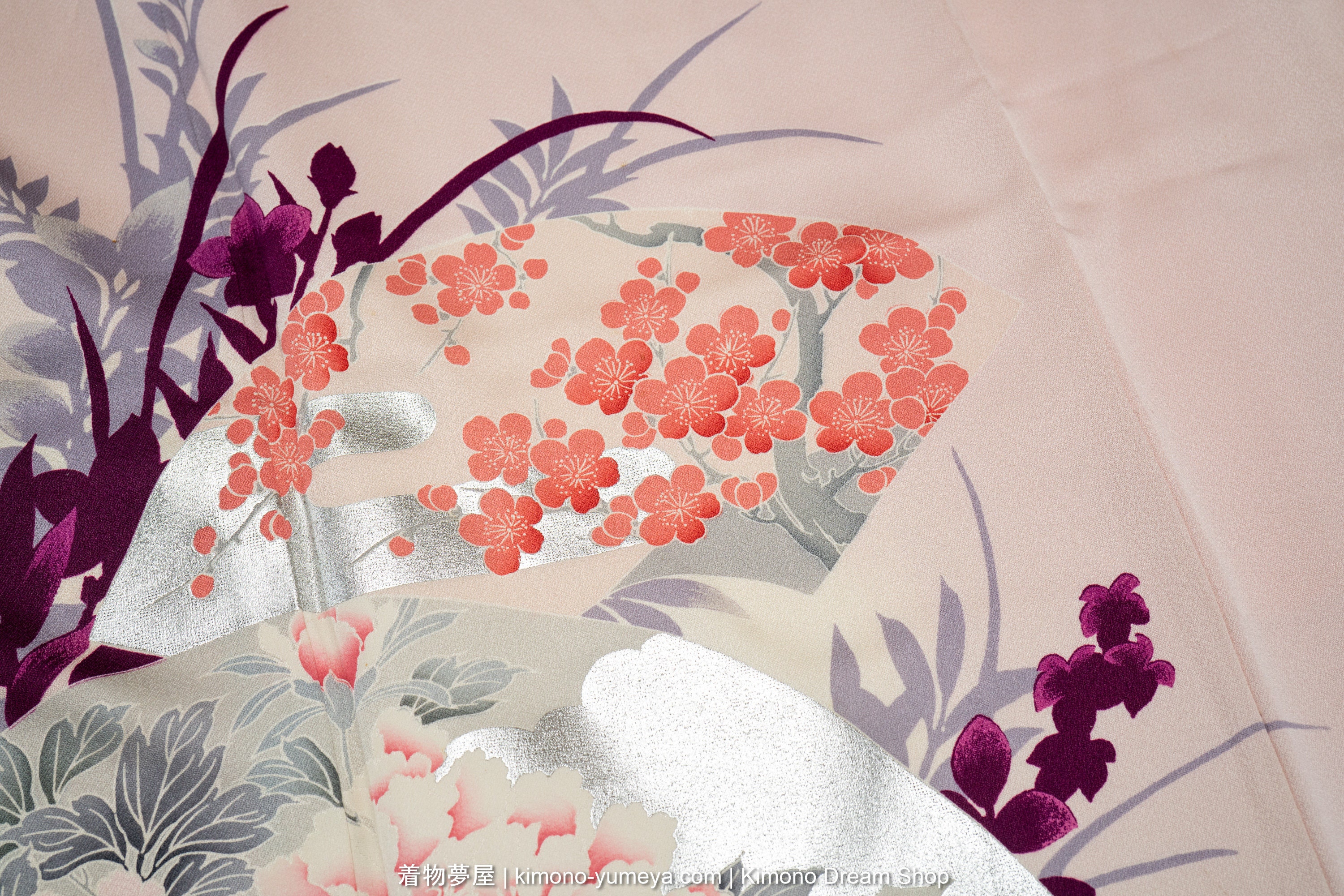 Pink plum blossoms on a gray tree, with silver clouds behind them, all on a folding fan.