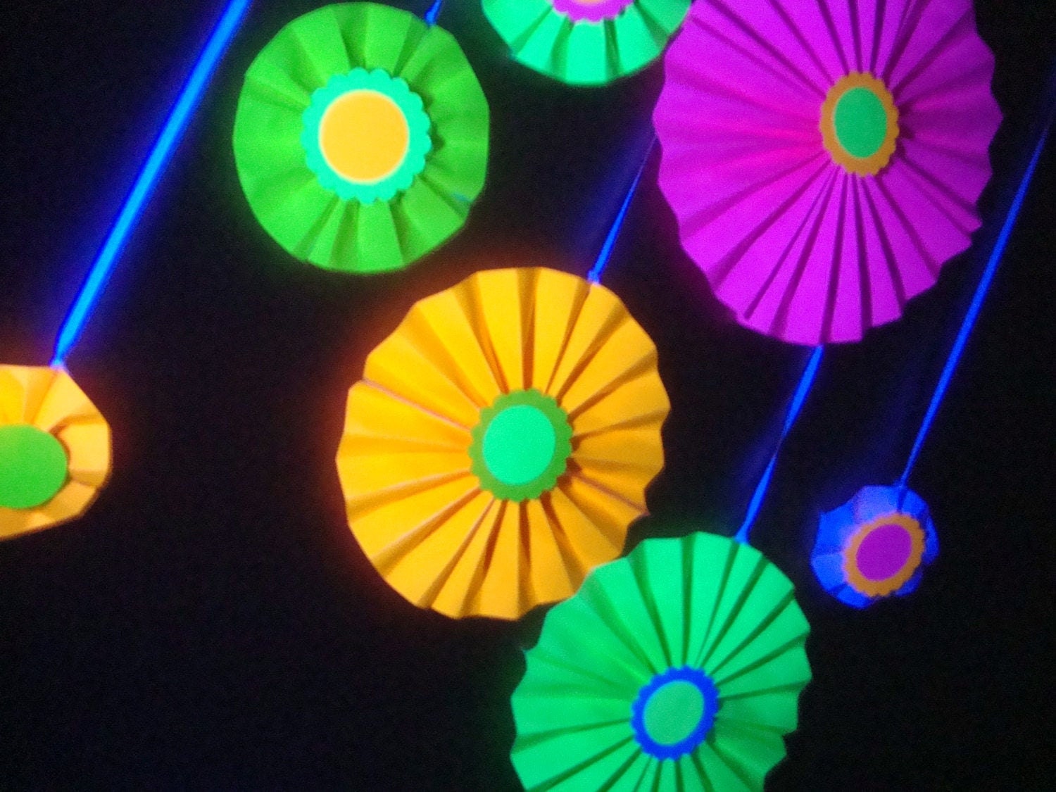 neon poster board folded into paper rosettes for a black light glow party