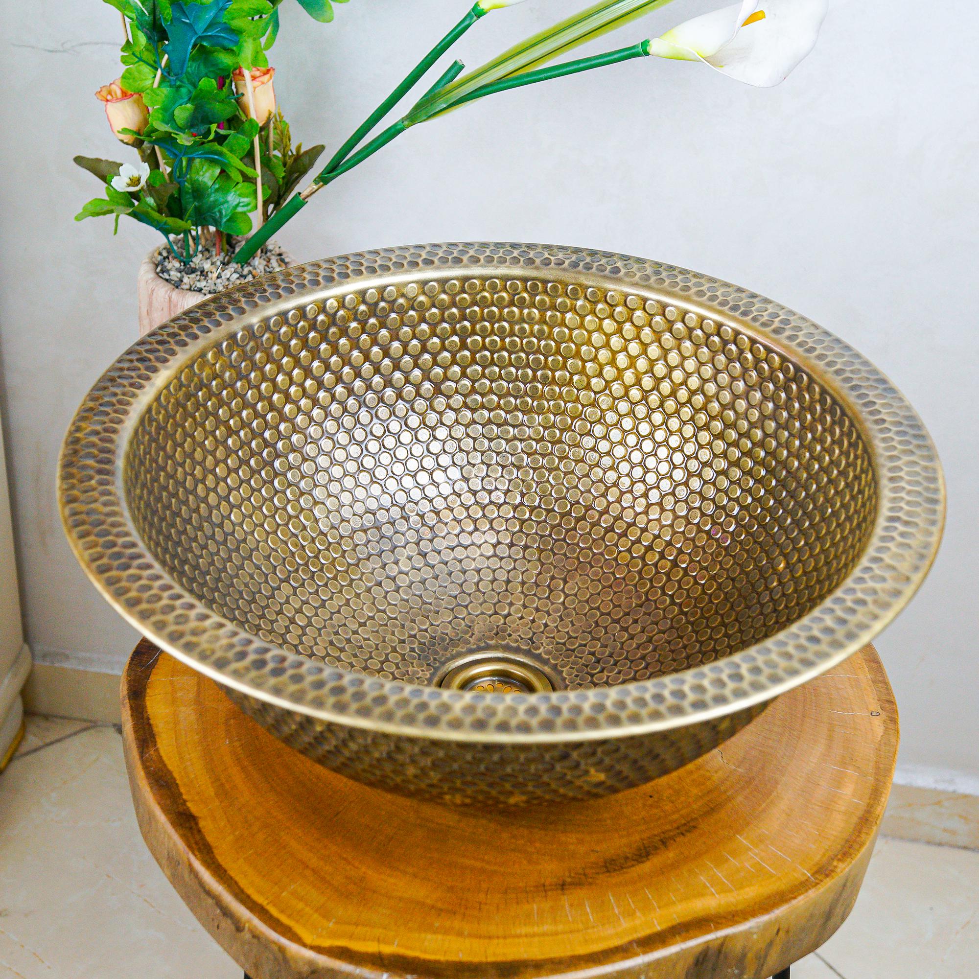 Bring Artisan Beauty Into Your Home  In a world where mass production often overshadows detail, artisan pieces—like hand-hammered brass sinks—stand out. The sink by HandicraftHomeDecors isn’t just a utility; it’s a work of art. Crafted in Morocco, each basin is shaped and hammered by skilled hands, resulting in unique texture, shine, and character.   Why Choose Brass?  Durability: Brass is known for long life and resistance to corrosion (especially when properly cared for).  Warmth & Patina: Over time, brass develops a beautiful, warm patina that adds depth and personality.  Antimicrobial Qualities: Metals like brass naturally resist certain bacteria, making them hygienic for sinks.  Key Features & Customisation Feature Detail Sizes available 8-inch (20 cm), 10-inch (25 cm), 12-inch (30 cm), 14-inch (35 cm), 16-inch (40 cm), 18-inch (45 cm)    Styles Vessel, drop-in, or undermount based on preference    Finish & Material 100% brass, hand hammered; the texture is natural with a Moroccan aesthetic    Seller & Origin Made by HandicraftHomeDecors, based in Casablanca, Morocco; 5-star reviews; Star Seller status   Styling Tips  Pair it with warm lighting (soft yellow or amber tones) to emphasize the brass glow.  Use simple, natural materials around it — wood, stone, matte finishes — so the sink remains the focal point.  Consider darker tones (charcoal, slate, deep greens) in countertop or cabinetry to contrast the brass.  Care & Maintenance  To keep the sink looking its best:  Clean gently with mild soap and water; avoid harsh abrasives or chlorine bleach.  Wipe dry after use so water spots don’t accumulate.  Occasionally polish if you like a shiny finish; allow natural patina if you prefer a more aged, artisan look.  Value & Why It’s Worth It  Paying a little more for handmade means:  Supporting local artisans and preserving traditional techniques.  Getting a piece that’s unique — no two hammered surfaces are identical.  Having options: size, finish, style to fit your space and taste.  Call to Action / Closing  If you’re looking to upgrade your bathroom from ordinary to extraordinary, this brass sink is more than a fixture—it’s a statement. Whether you want to evoke global heritage, artisan luxury, or simply bring warmth and texture into your daily routine, this sink delivers.
