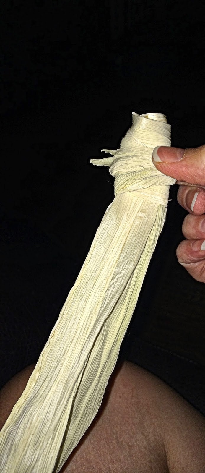 Third corn husk wrapped around the top to form the head