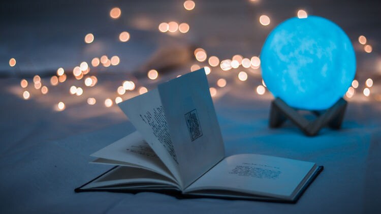 Book with Glowing Moon Ord Light in Background