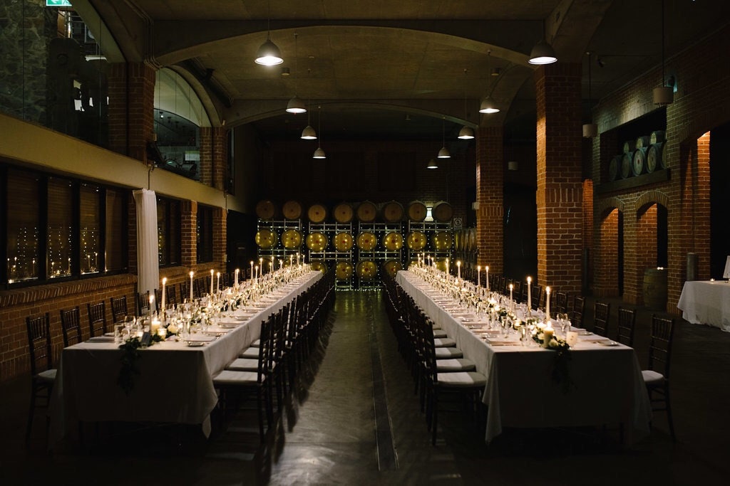 Wide angle view of wedding reception long tables with custom stationery and decor