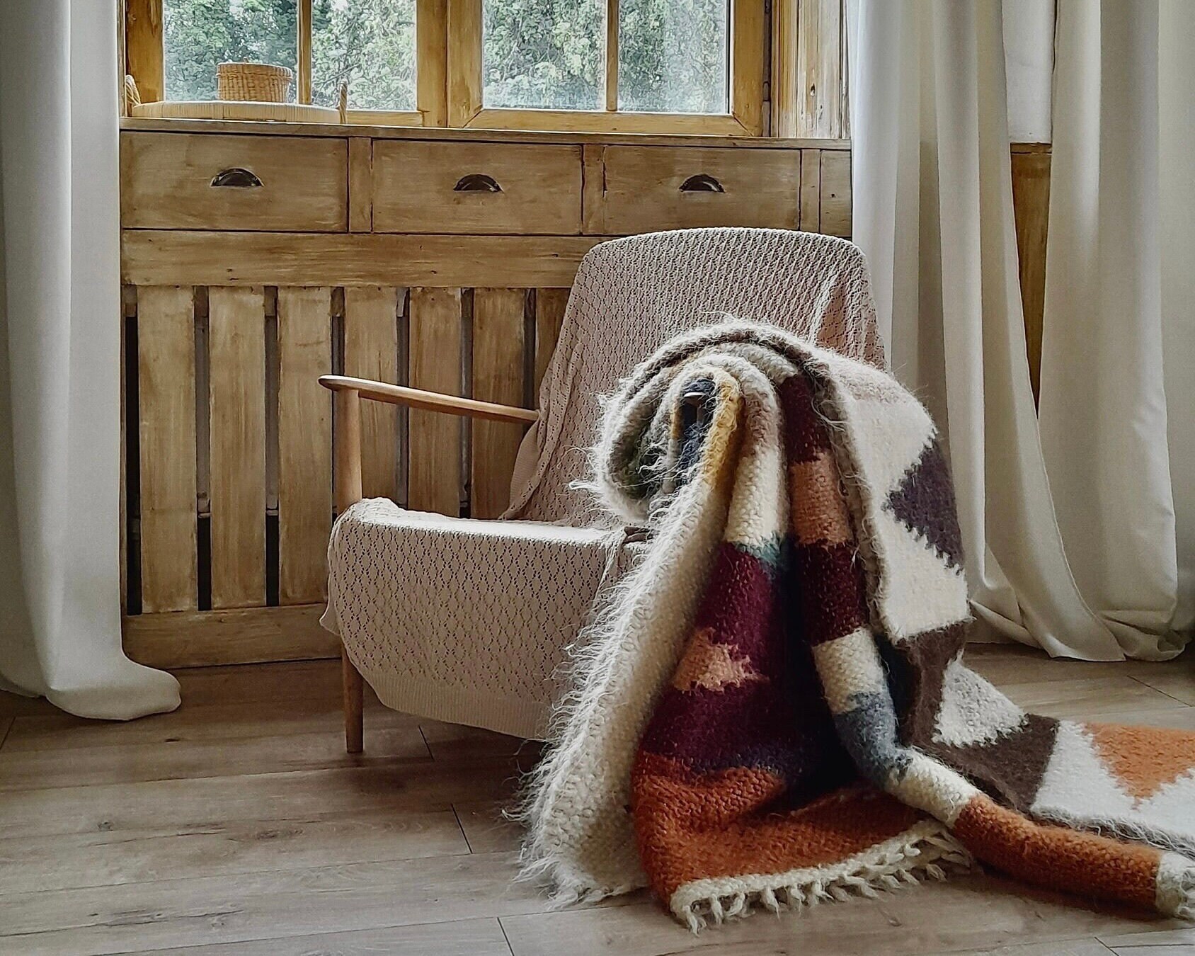 Bohemian-inspired living room with a colorful rug, eclectic furniture, and vibrant artwork.