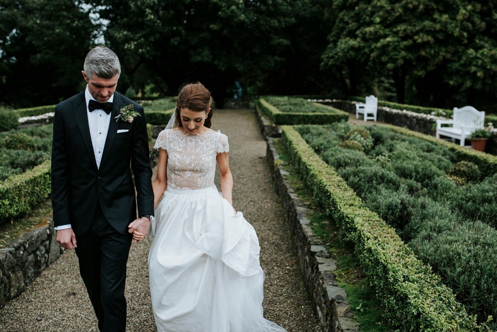 Bride and groom walking towards camera facing down