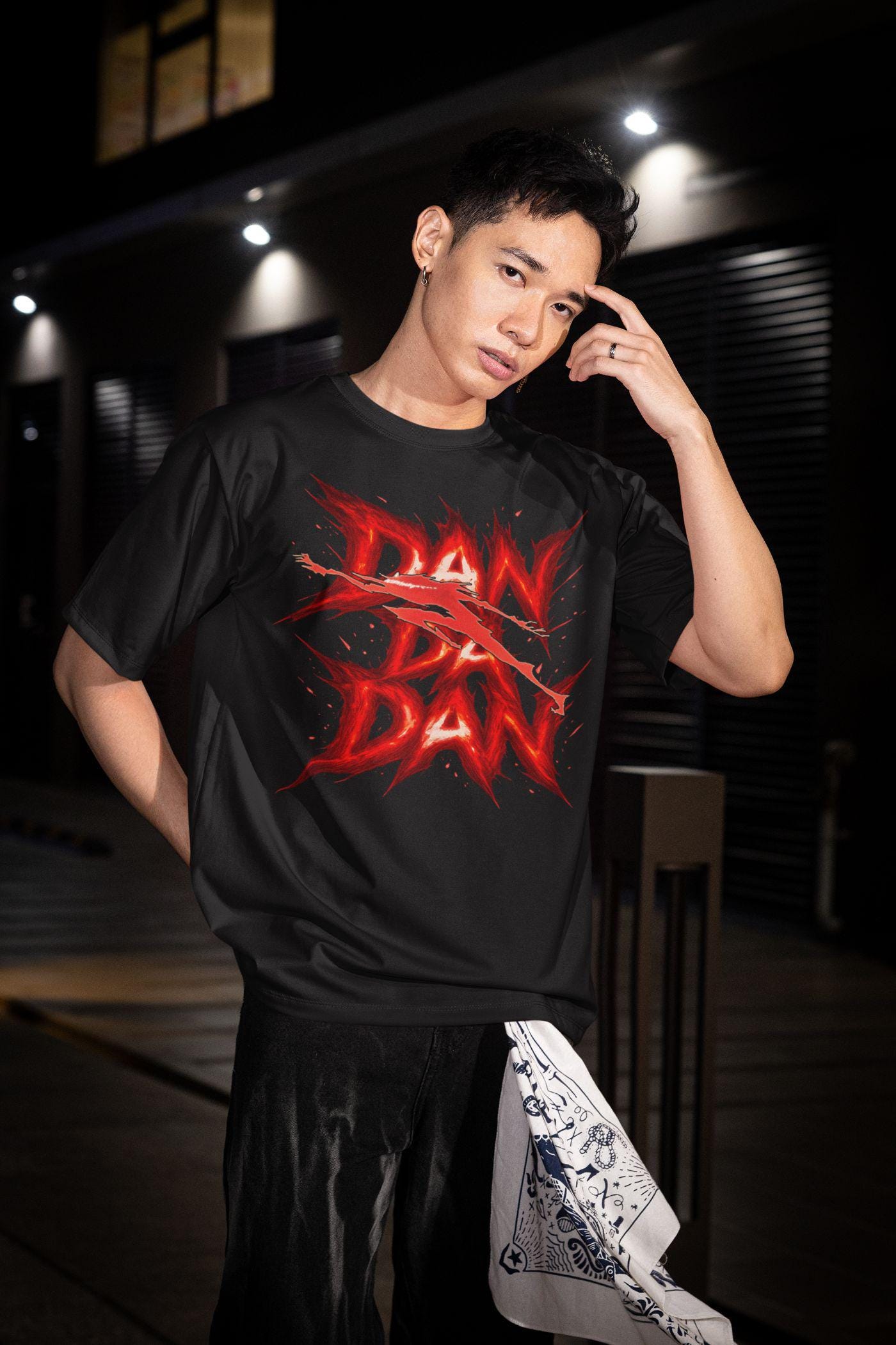 A man wearing the Pop Retro And Dreams black graphic tee, the best Dandadan anime merch for fans of Okarun and Momo.