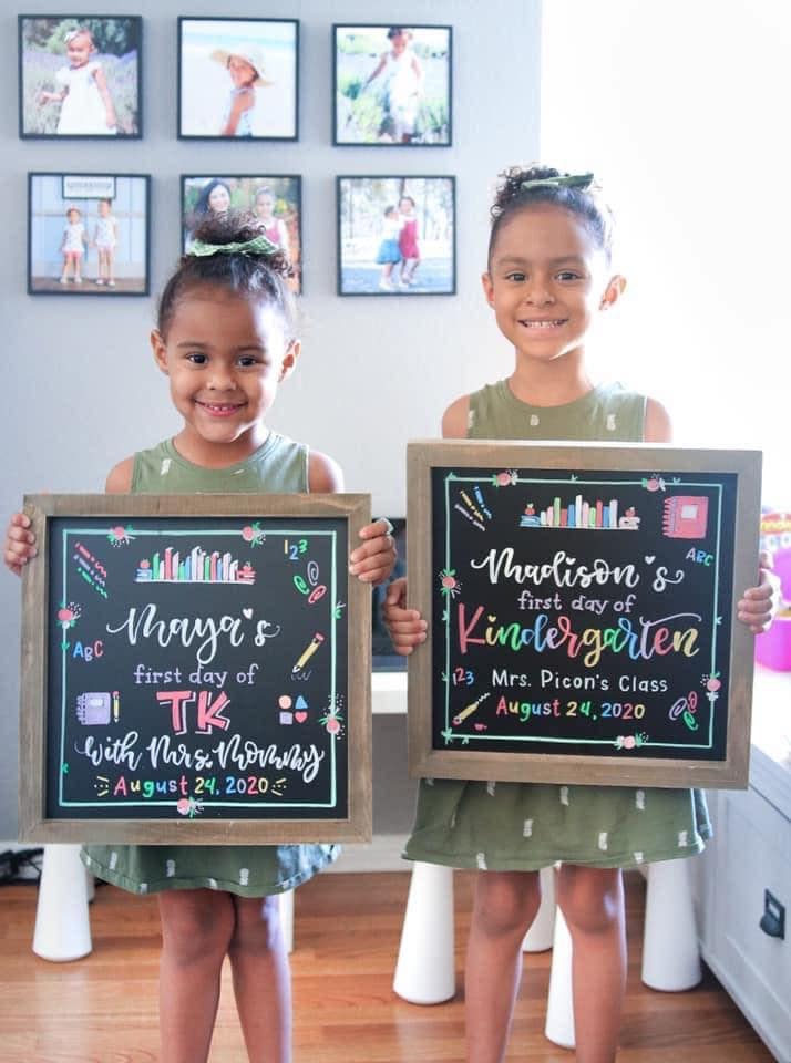 two girls holding back to school boards