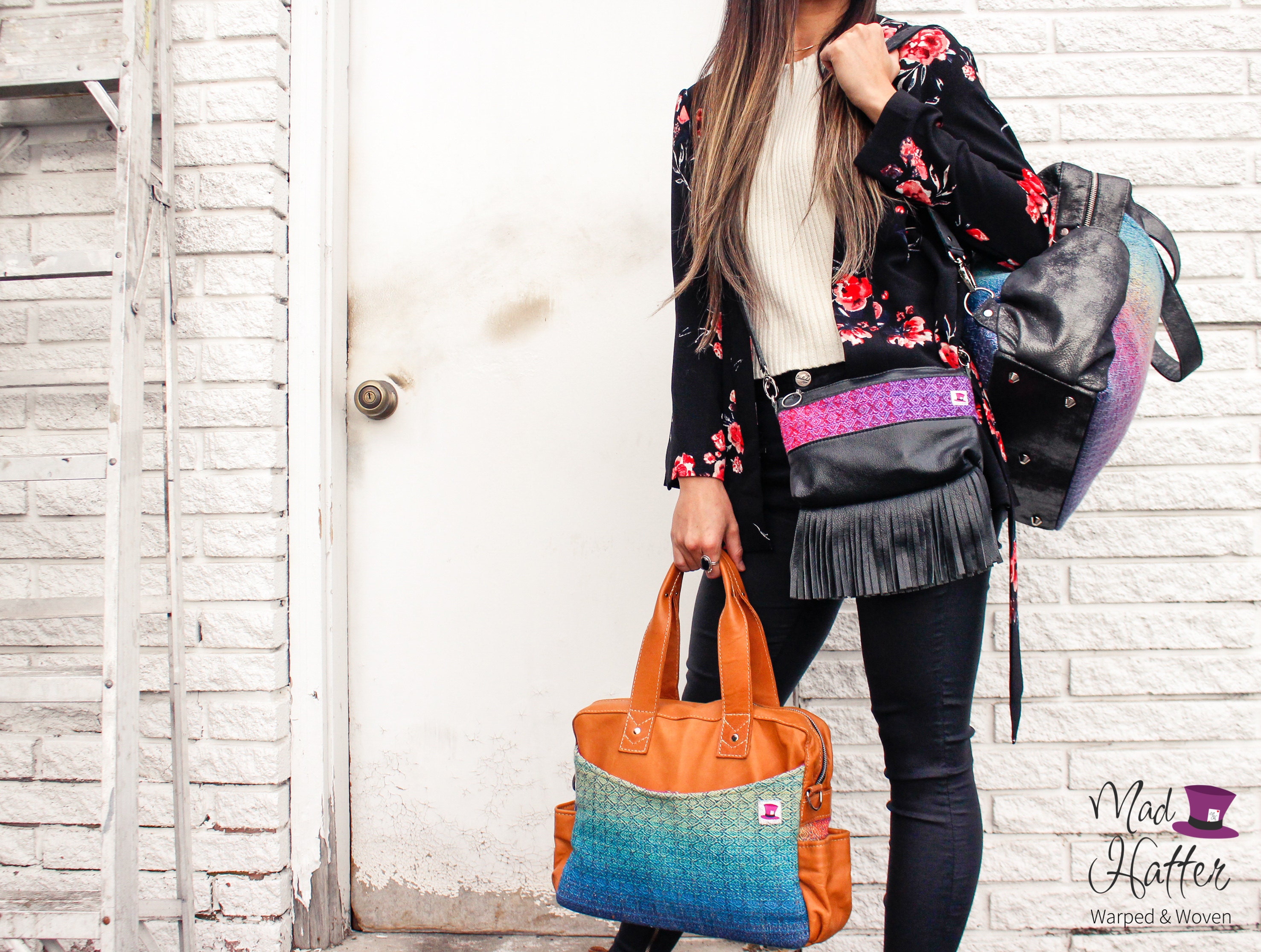 woman shown from the neck down holding three Mad Hatter Warped & Woven handbags including a Leo, Lovato, and Hartley.