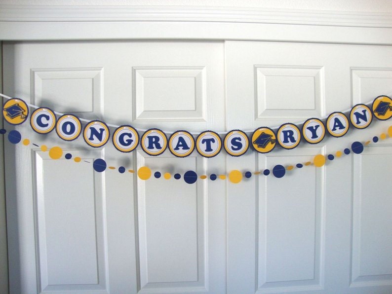Congrats Ryan graduation banner in navy and yellow with dot garlands